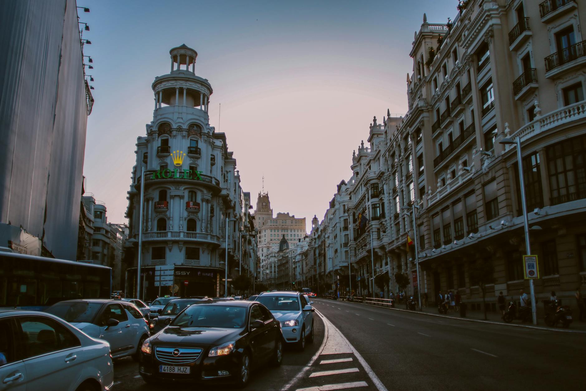 Evening traffic on Gran Via in Madrid with historic buildings and city lights