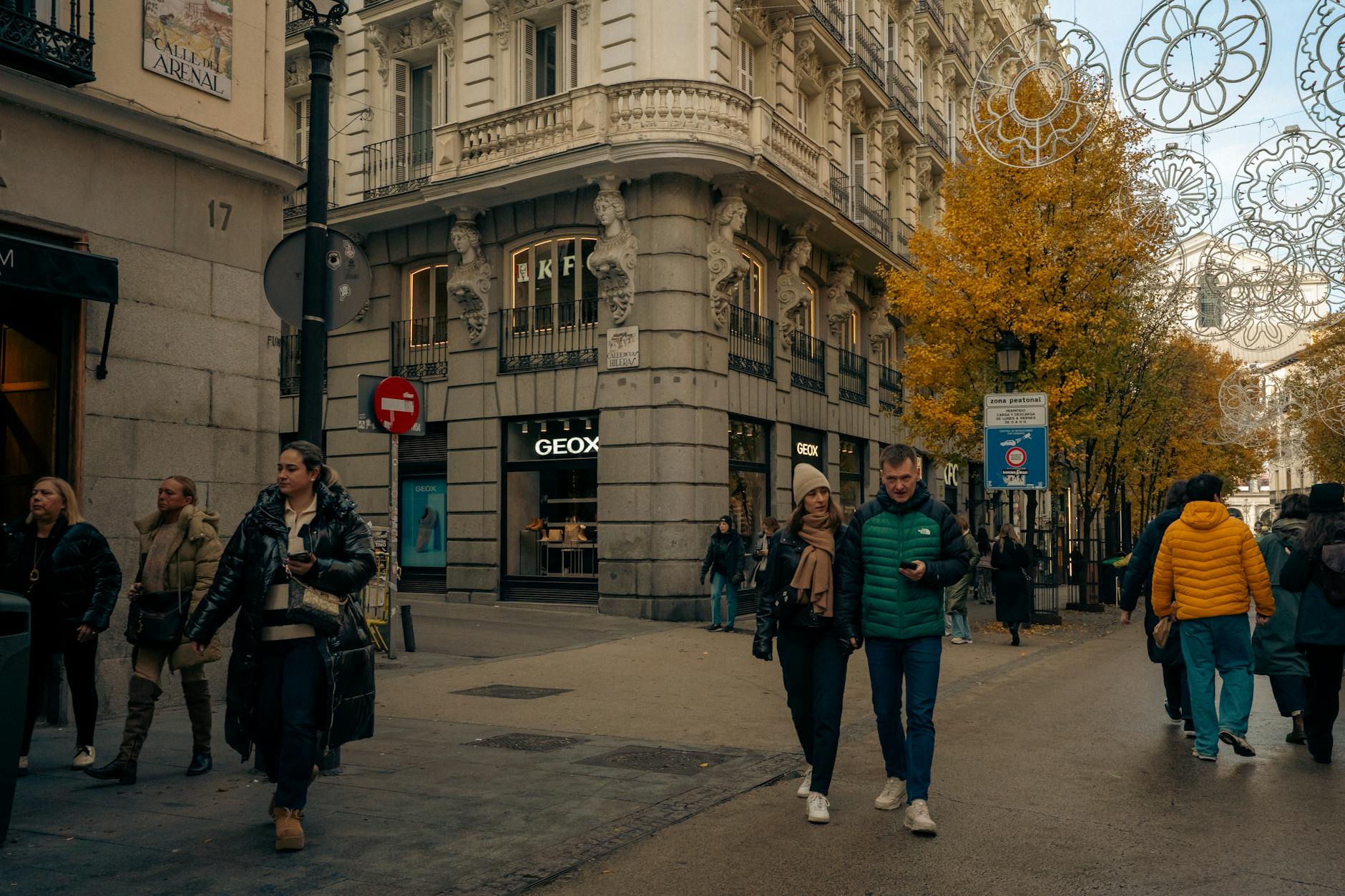 Madrid shopping street with autumn trees and pedestrians