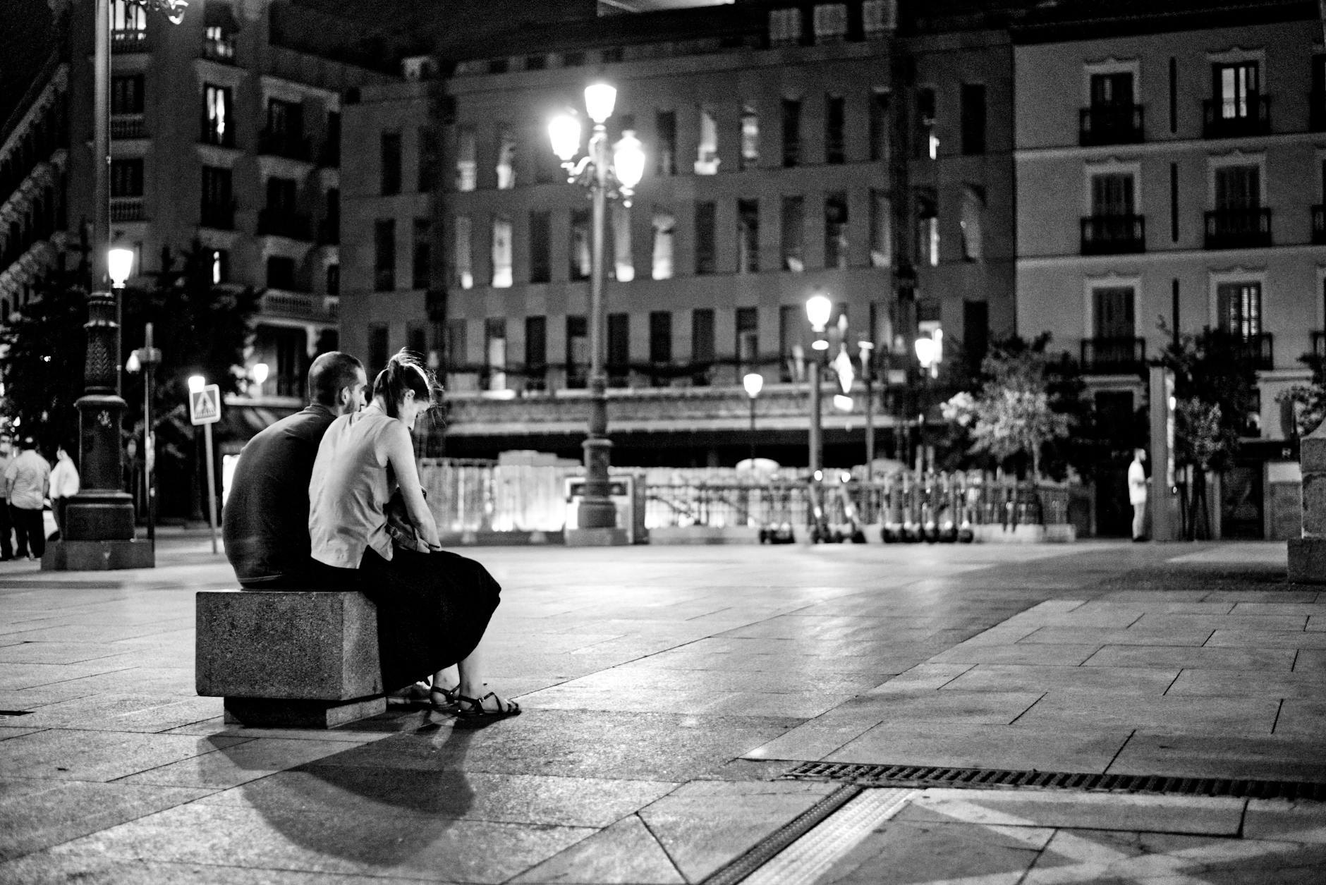 Couple sitting together at night in a Madrid square