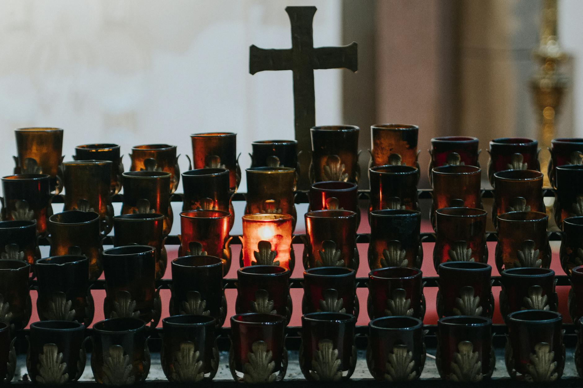 Votive candles glowing in a dim church interior