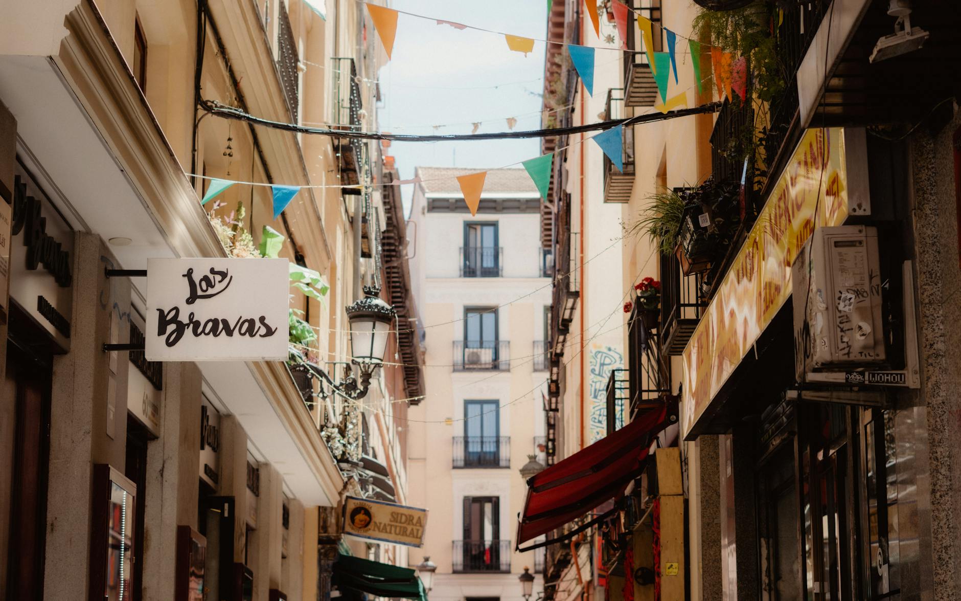 Madrid street with flags and traditional storefronts