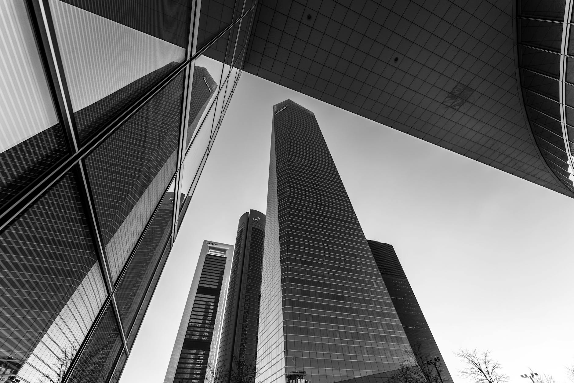 Low-angle view of Madrid business towers reflected in glass