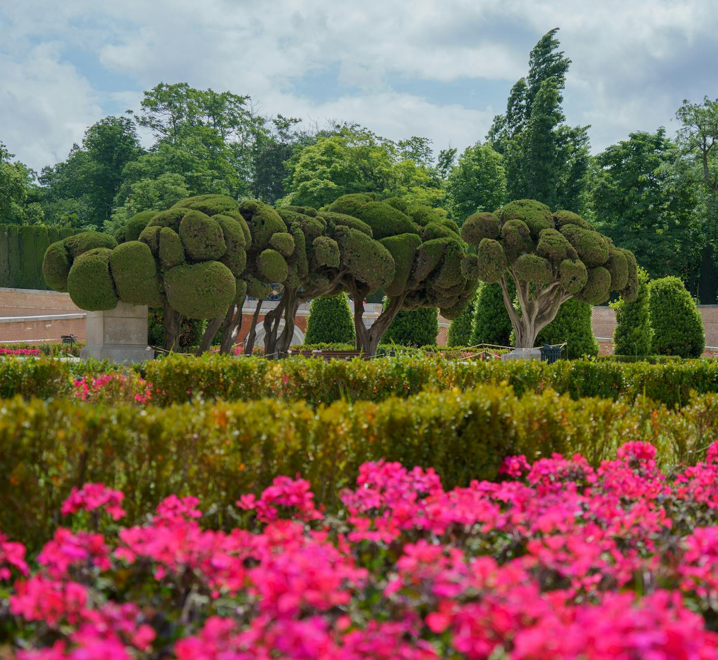 Flowers and sculpted trees in Retiro Park in Madrid