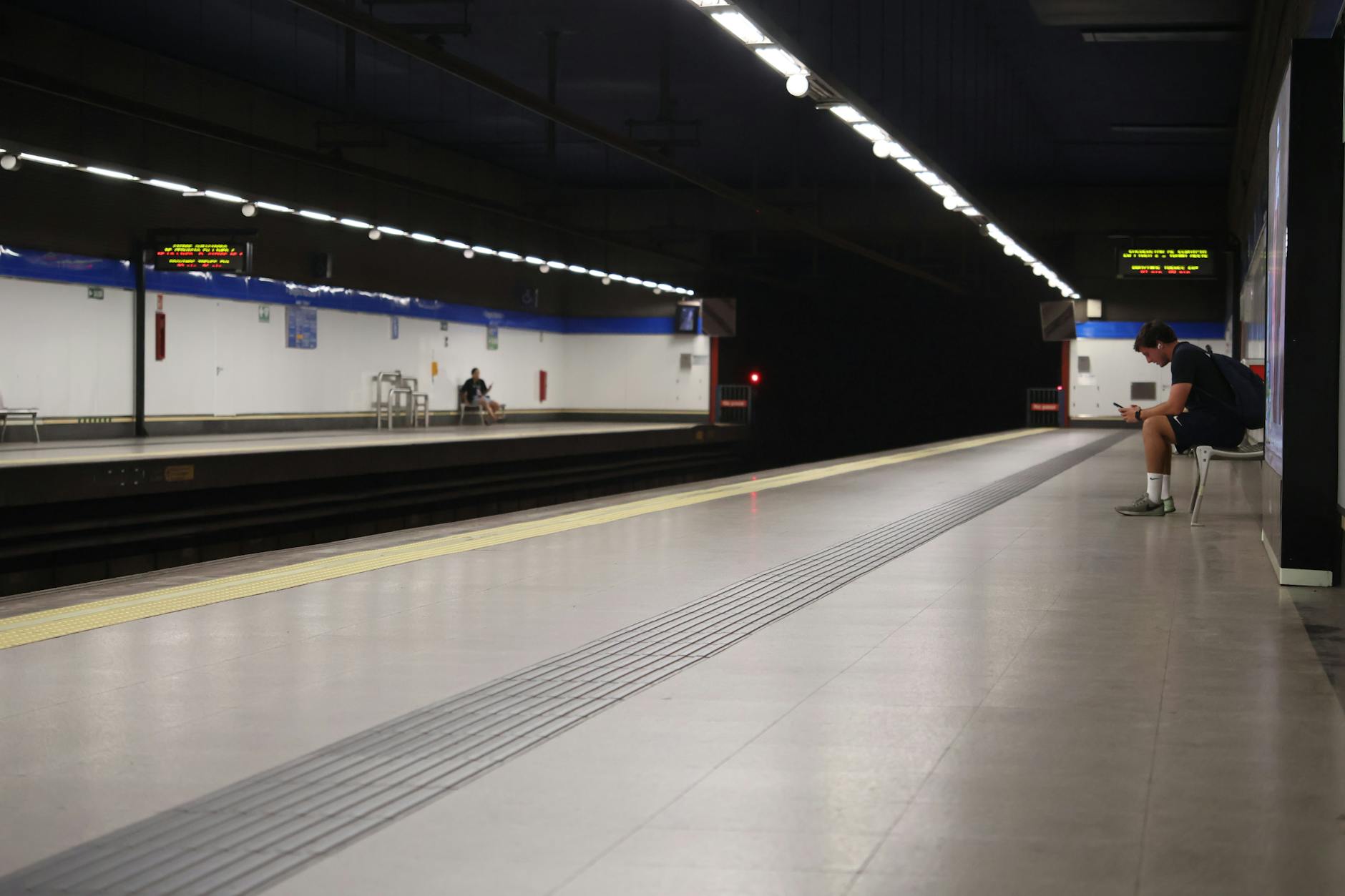 Solitary person waiting at a quiet subway station in Madrid at night