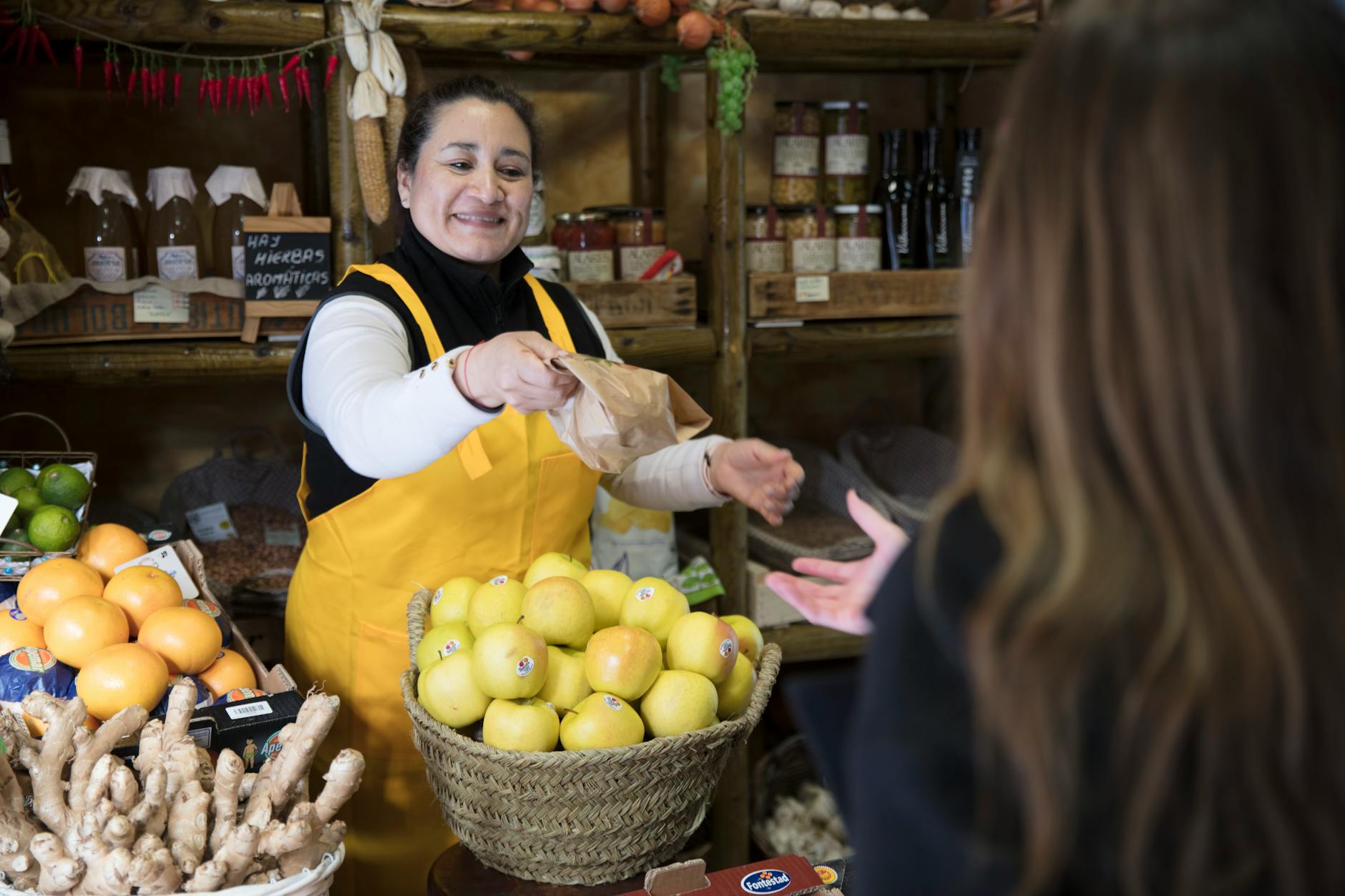 Madrid grocery vendor handing produce to a customer