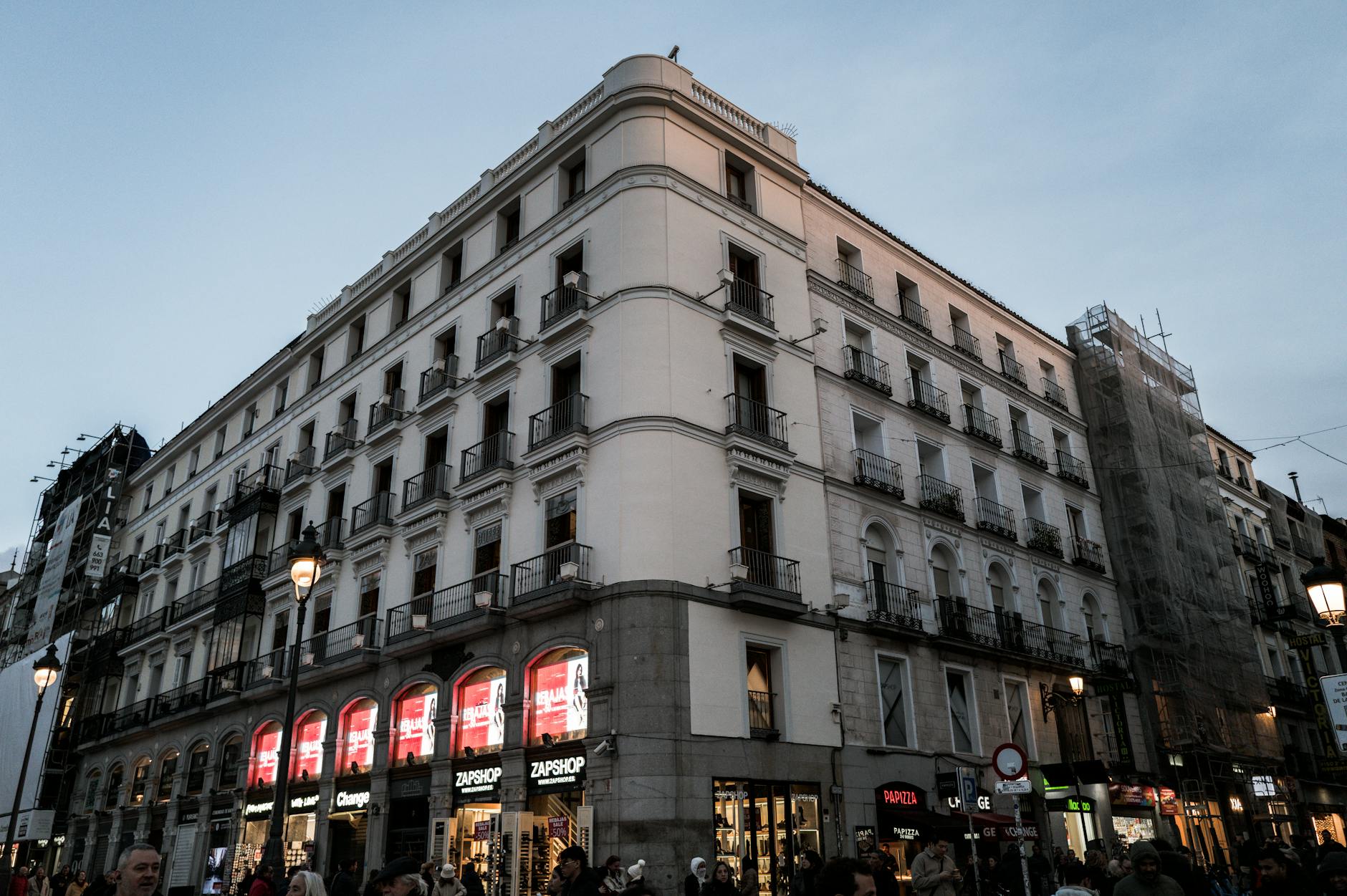 Madrid city center illuminated at dusk with people in the street