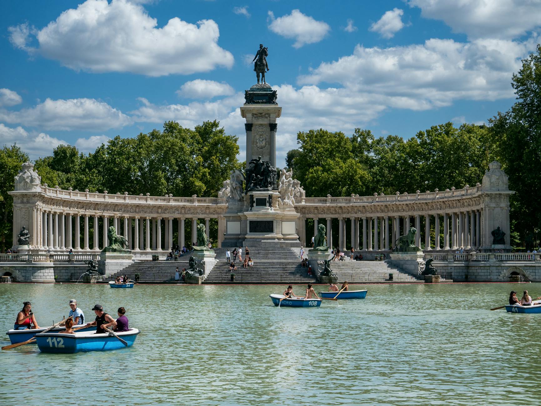 People boating at Retiro Park in Madrid near the Alfonso XII monument