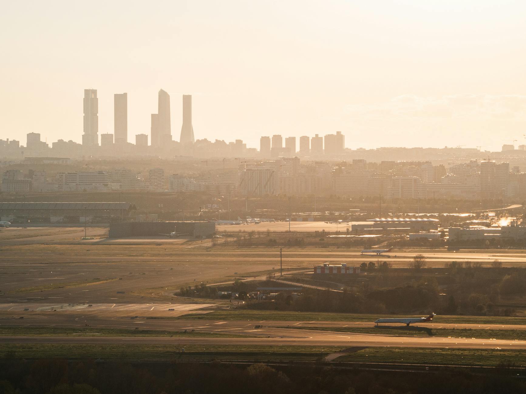 Madrid skyline and runway at golden-hour sunset