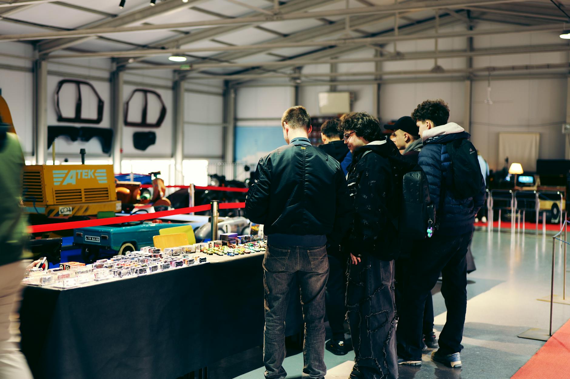 Attendees examining models at an indoor automotive exhibition