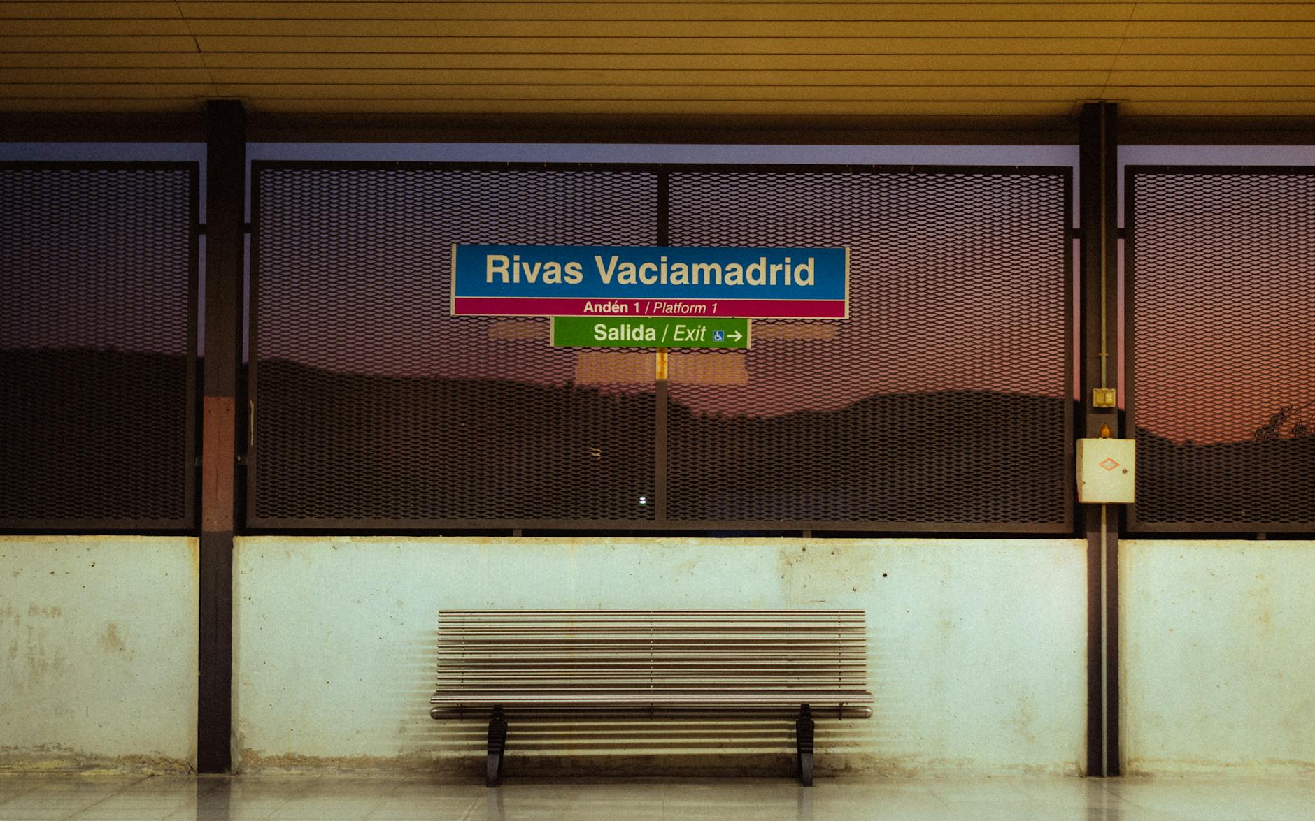Quiet Madrid metro station at dusk with an empty bench