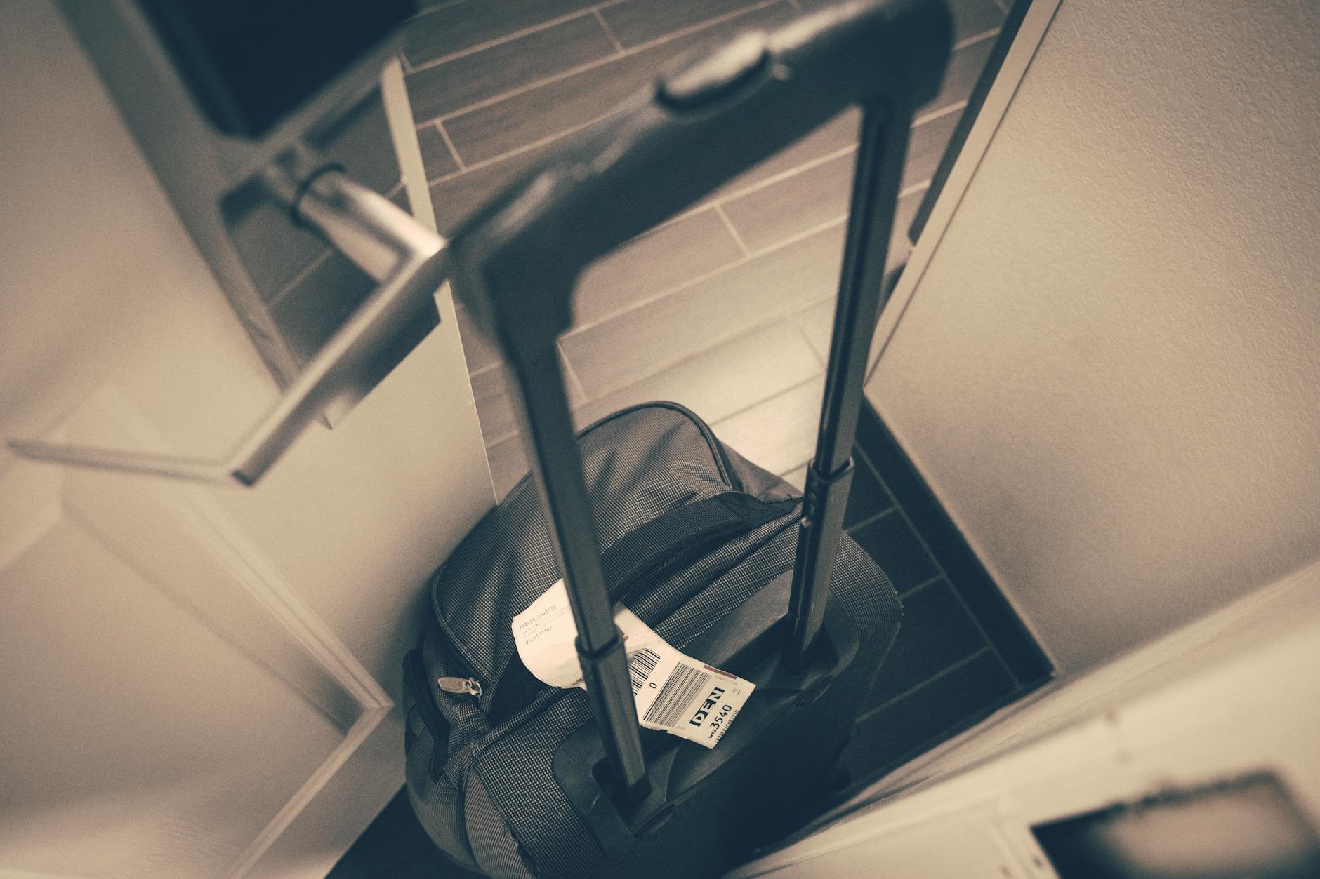 Travel suitcase with tag beside a hotel door