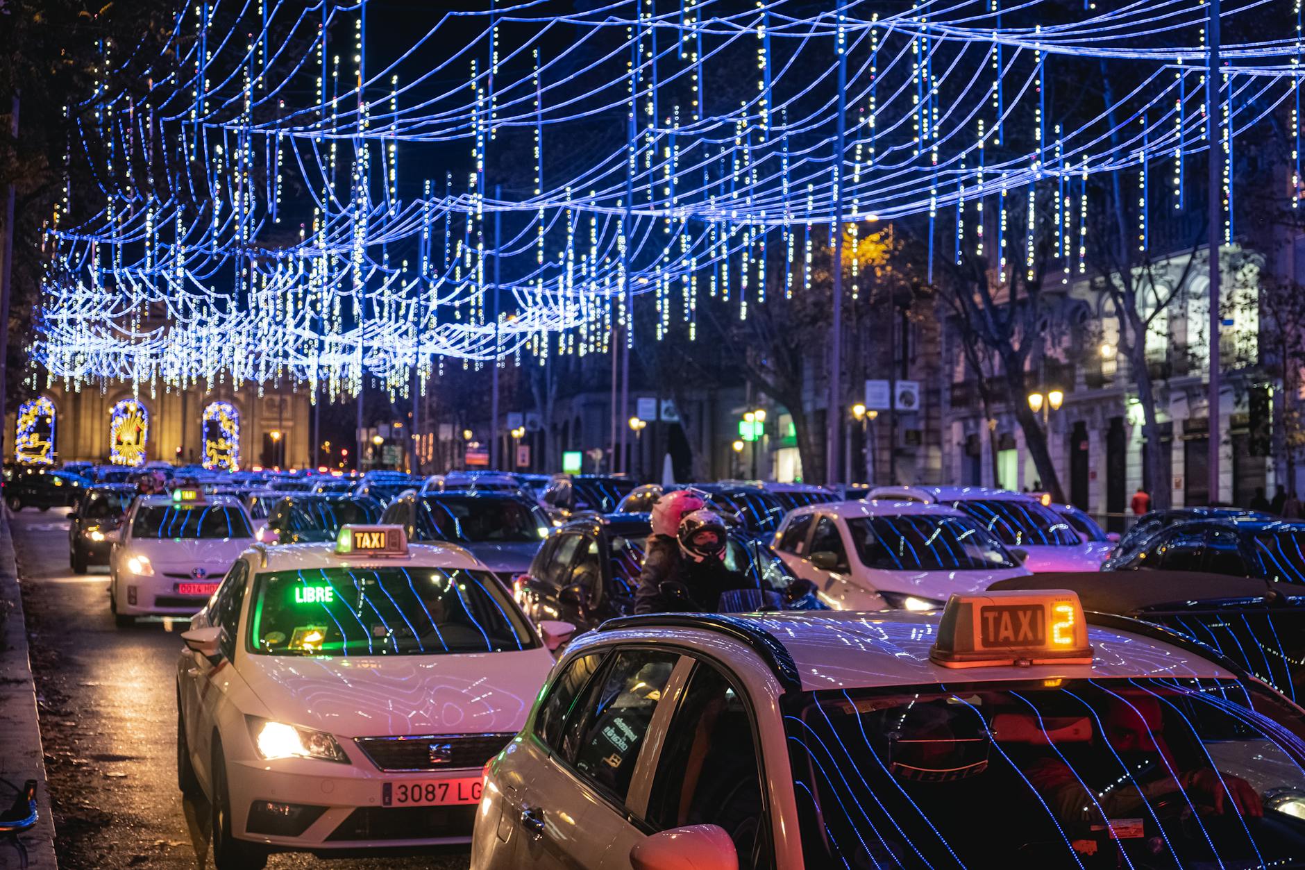 Madrid street with taxis and festive lights at night