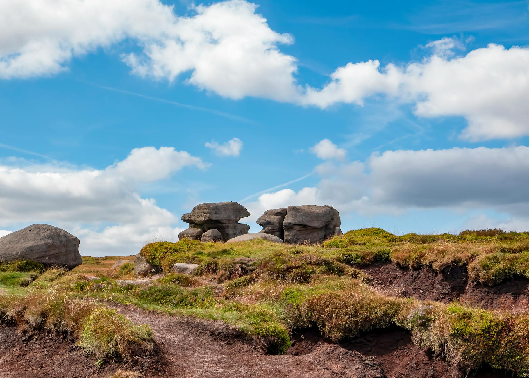 Kinder Scout landscape with rocky formations under blue sky