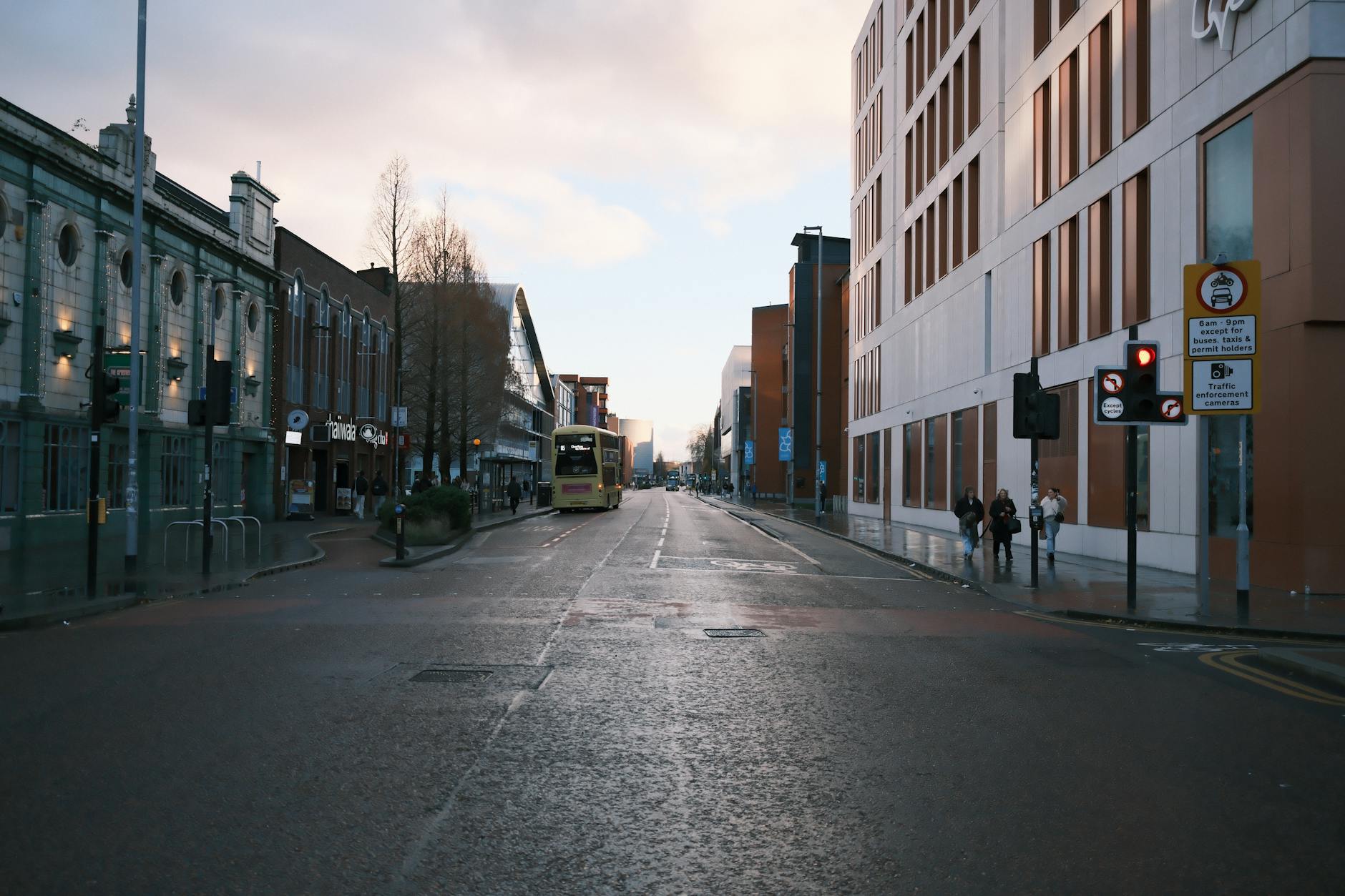 Manchester street with a double decker bus under cloudy skies