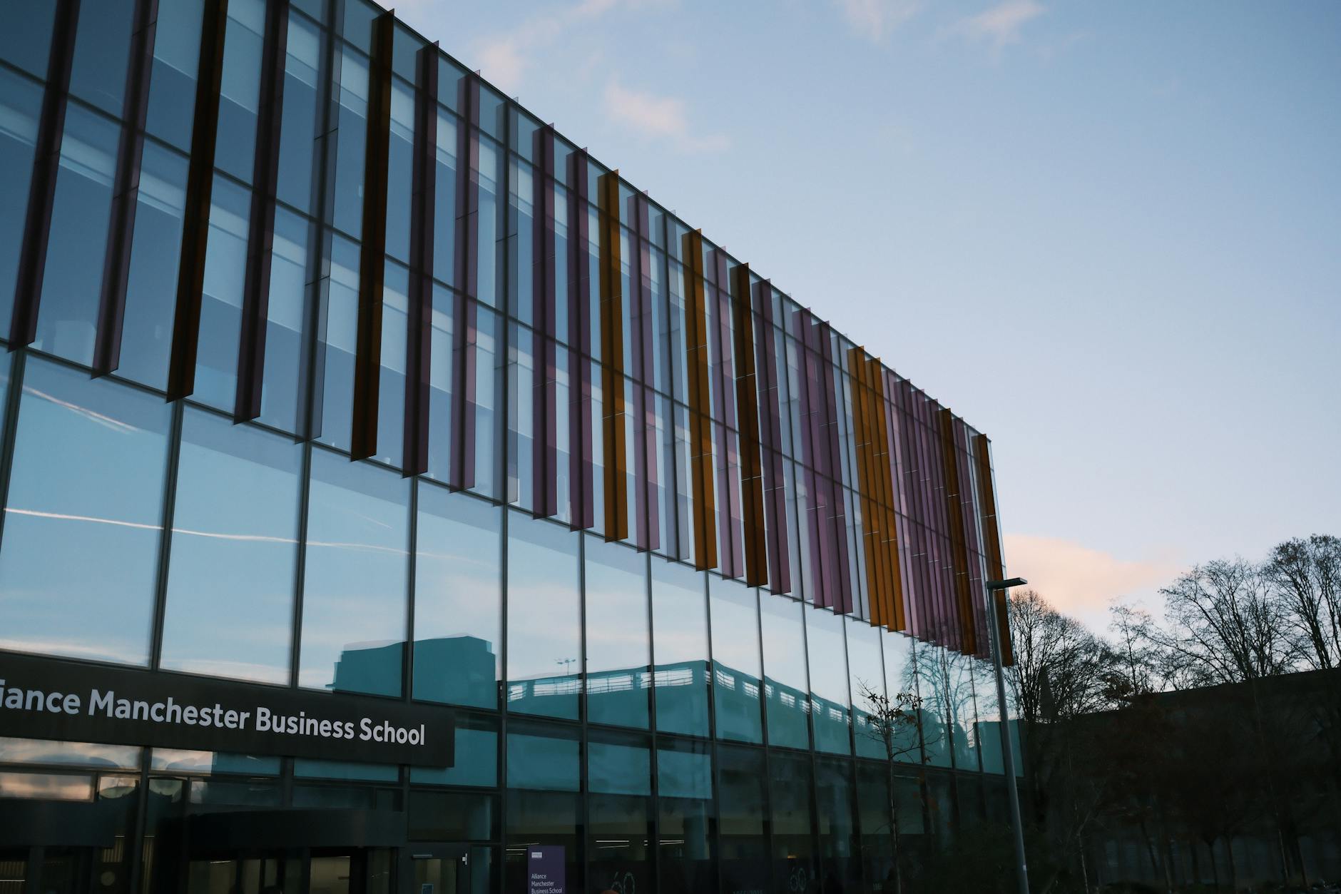 Alliance Manchester Business School building reflected in glass at dusk