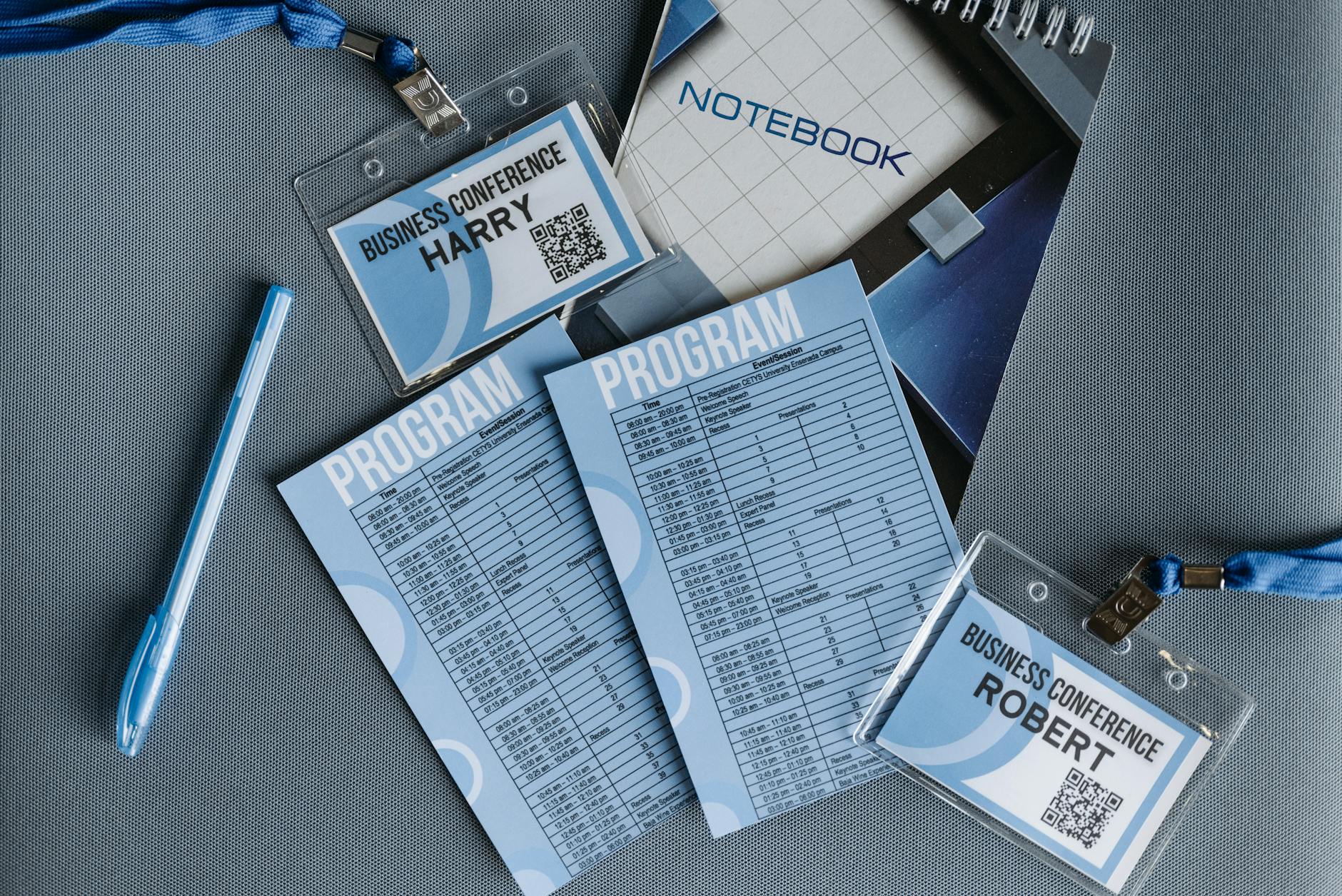 Conference name tags, program, notebook, and pen arranged on a table