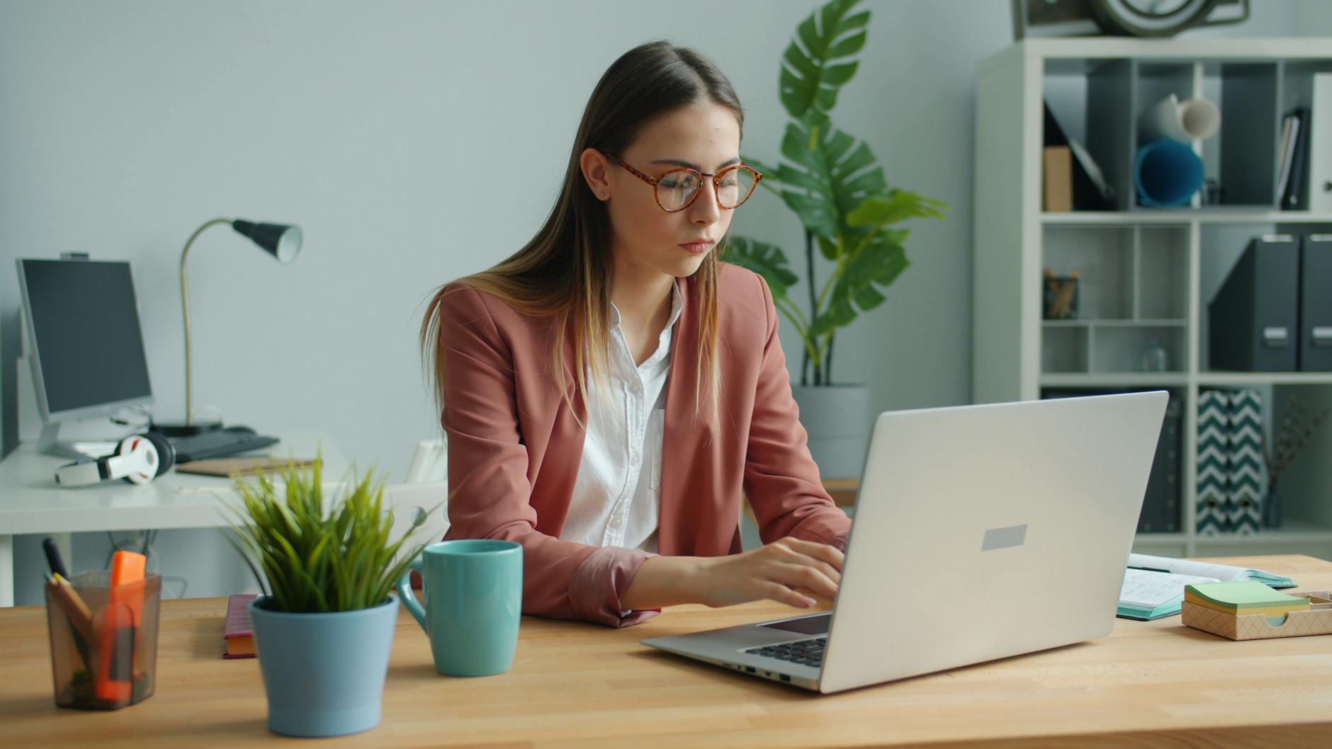 Professional using a laptop in a modern office setting