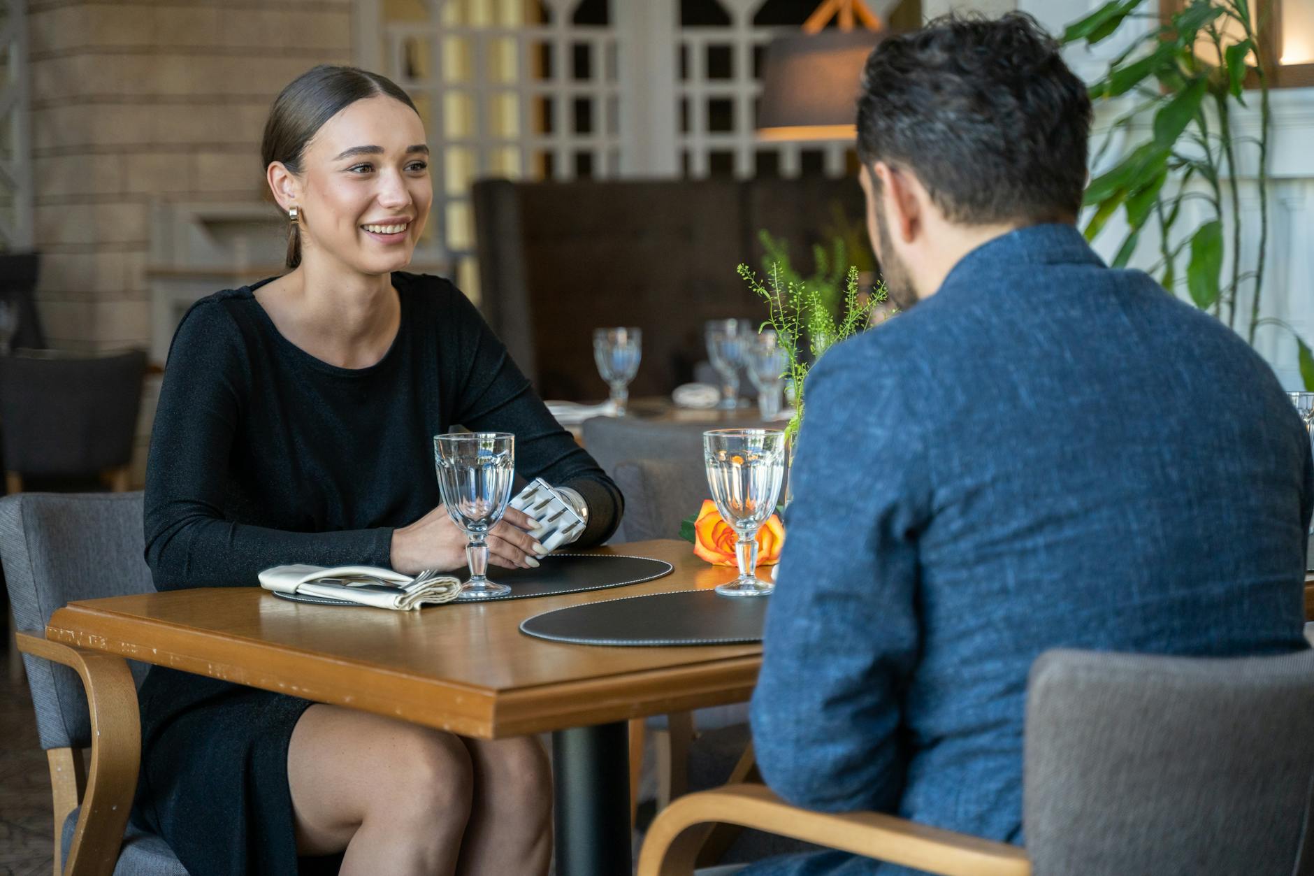 Two adults in a restaurant conversation over drinks