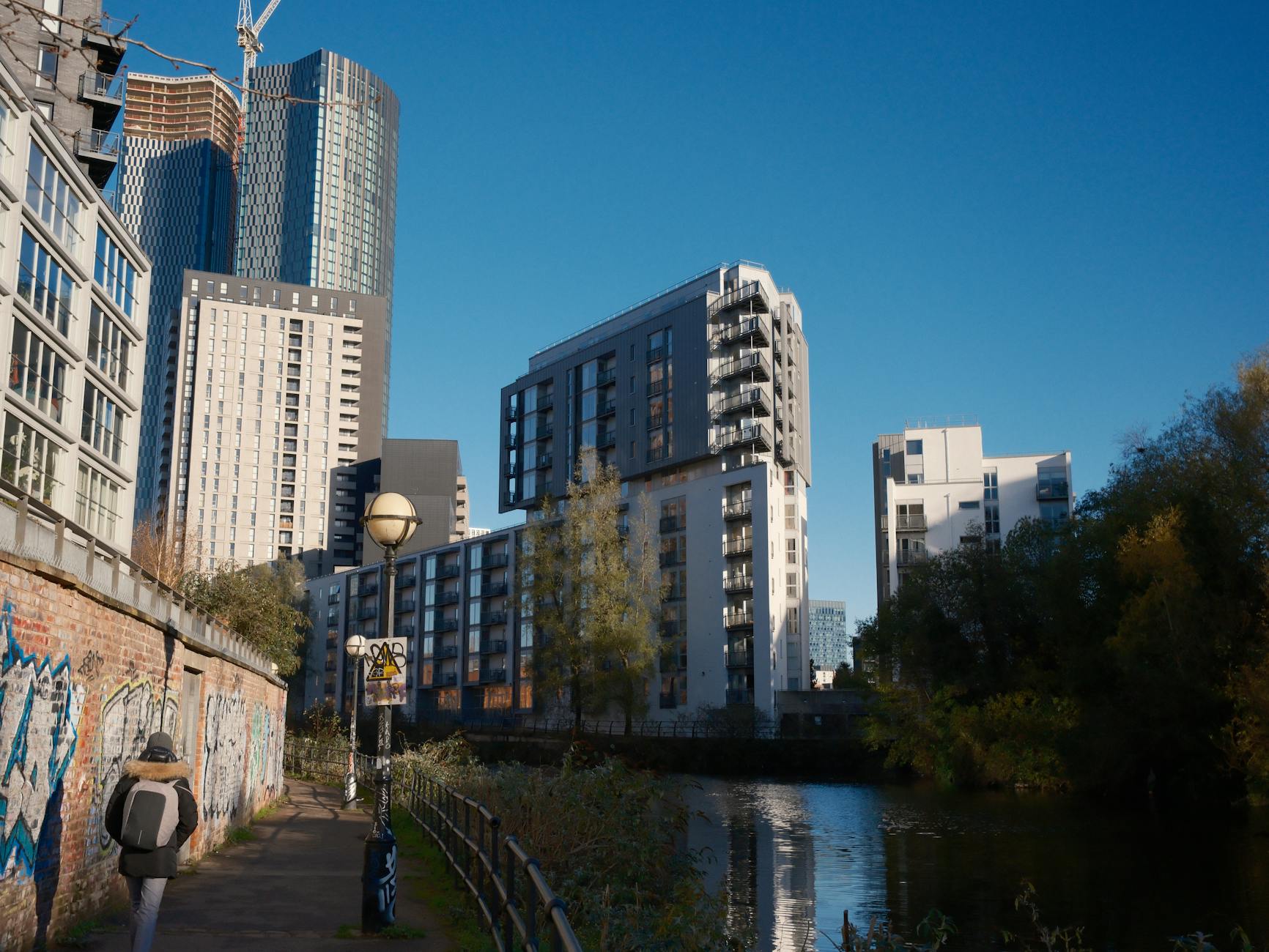 Manchester riverside path with skyscrapers and modern city views