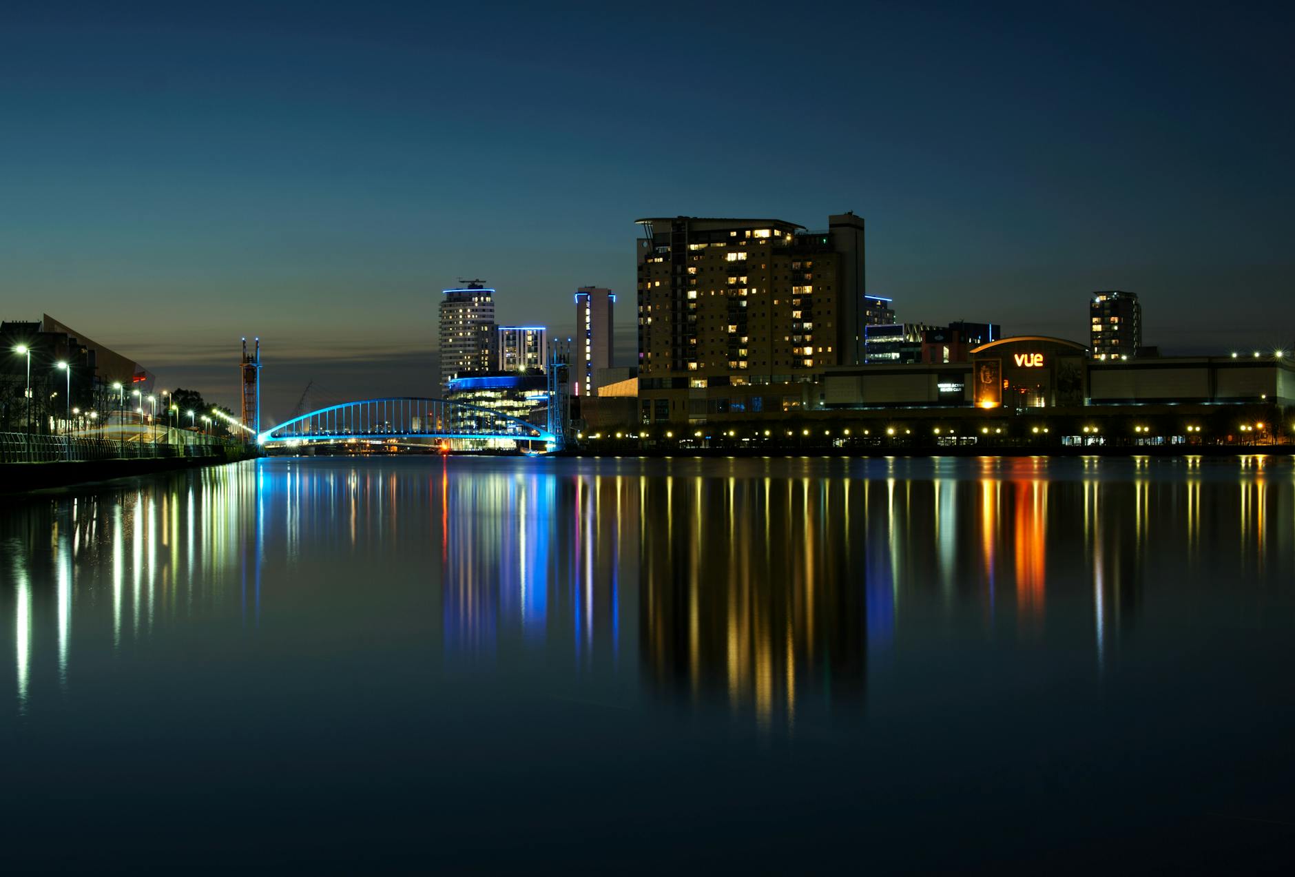 Salford Quays at night with illuminated buildings and water reflections