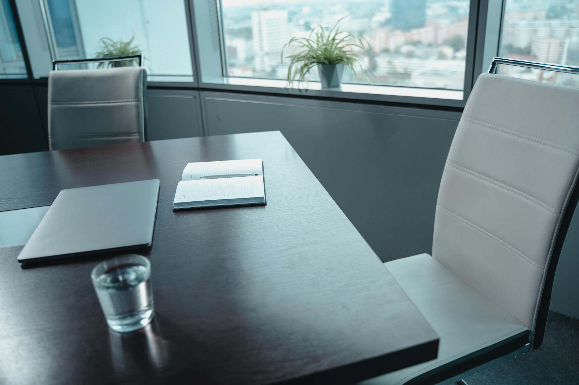 Conference-room table prepared with laptop and notebook