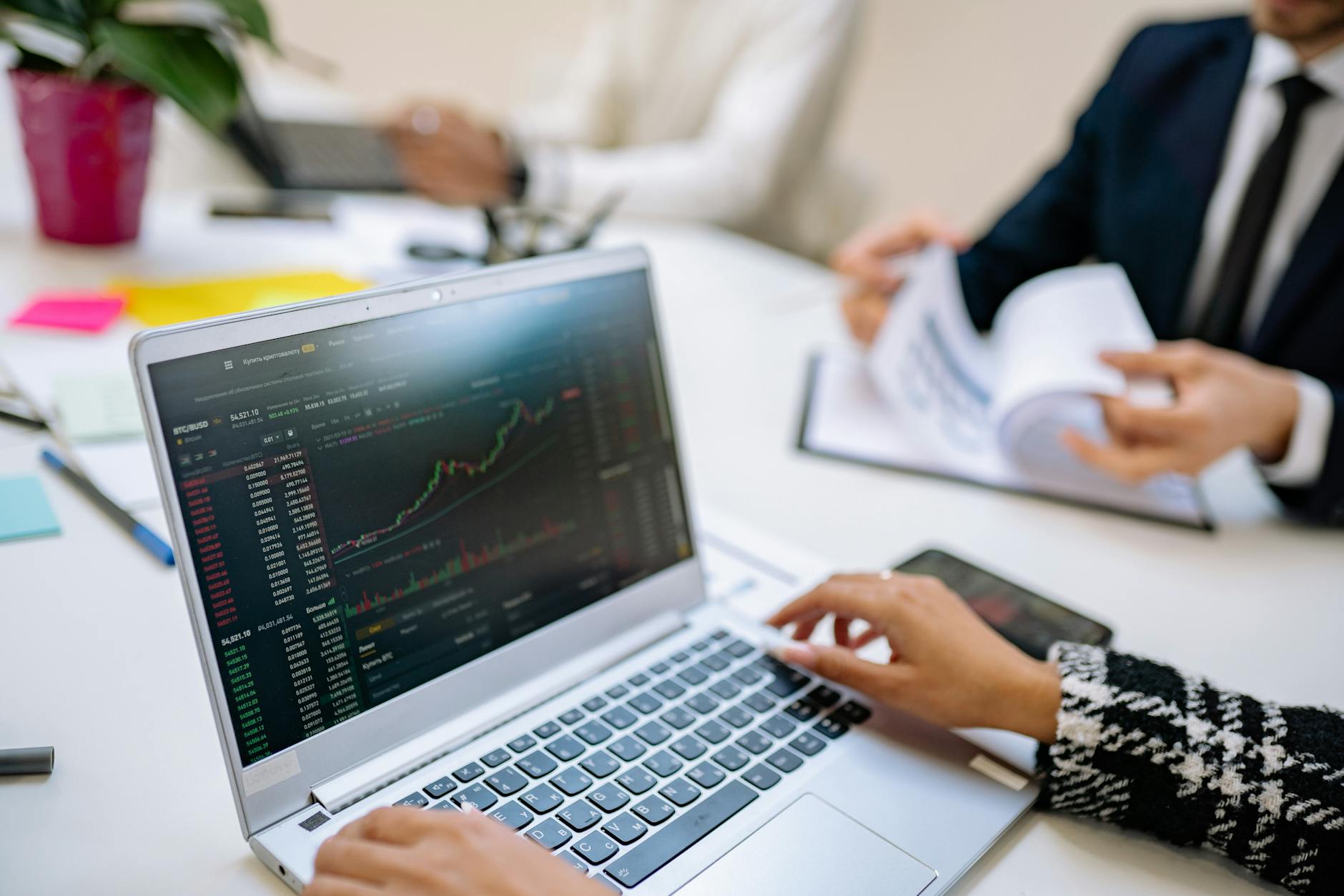 Business team reviewing financial charts and market data on a laptop