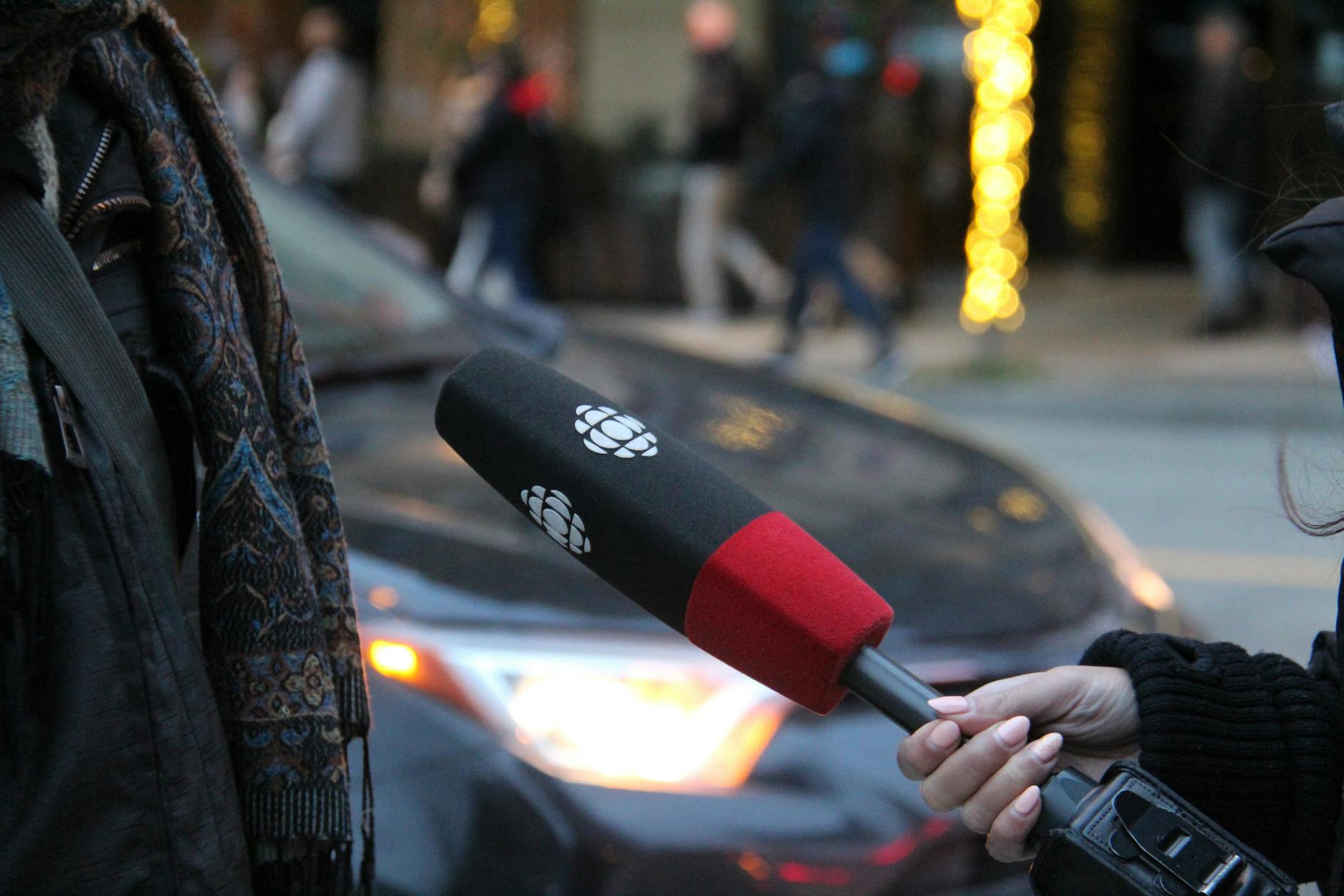 Reporter holding a microphone during a street interview