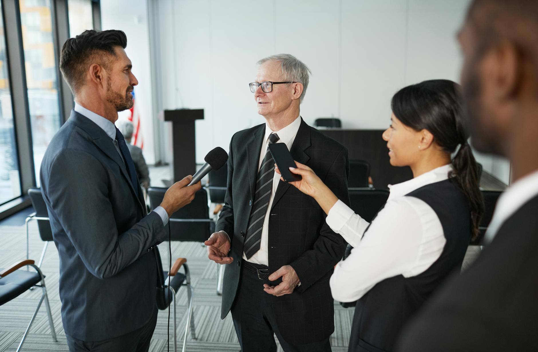 Journalists interviewing a senior executive in a meeting room