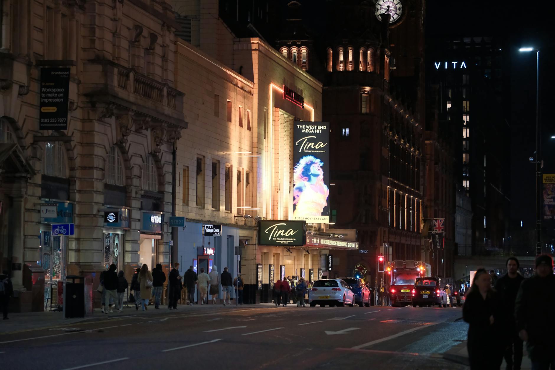 Busy Manchester theatre street illuminated at night