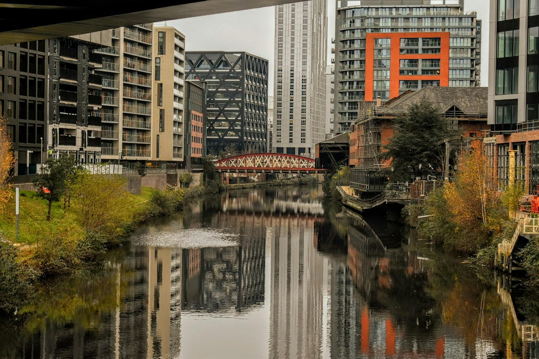 Quiet urban canal in Manchester with modern buildings reflected in the water
