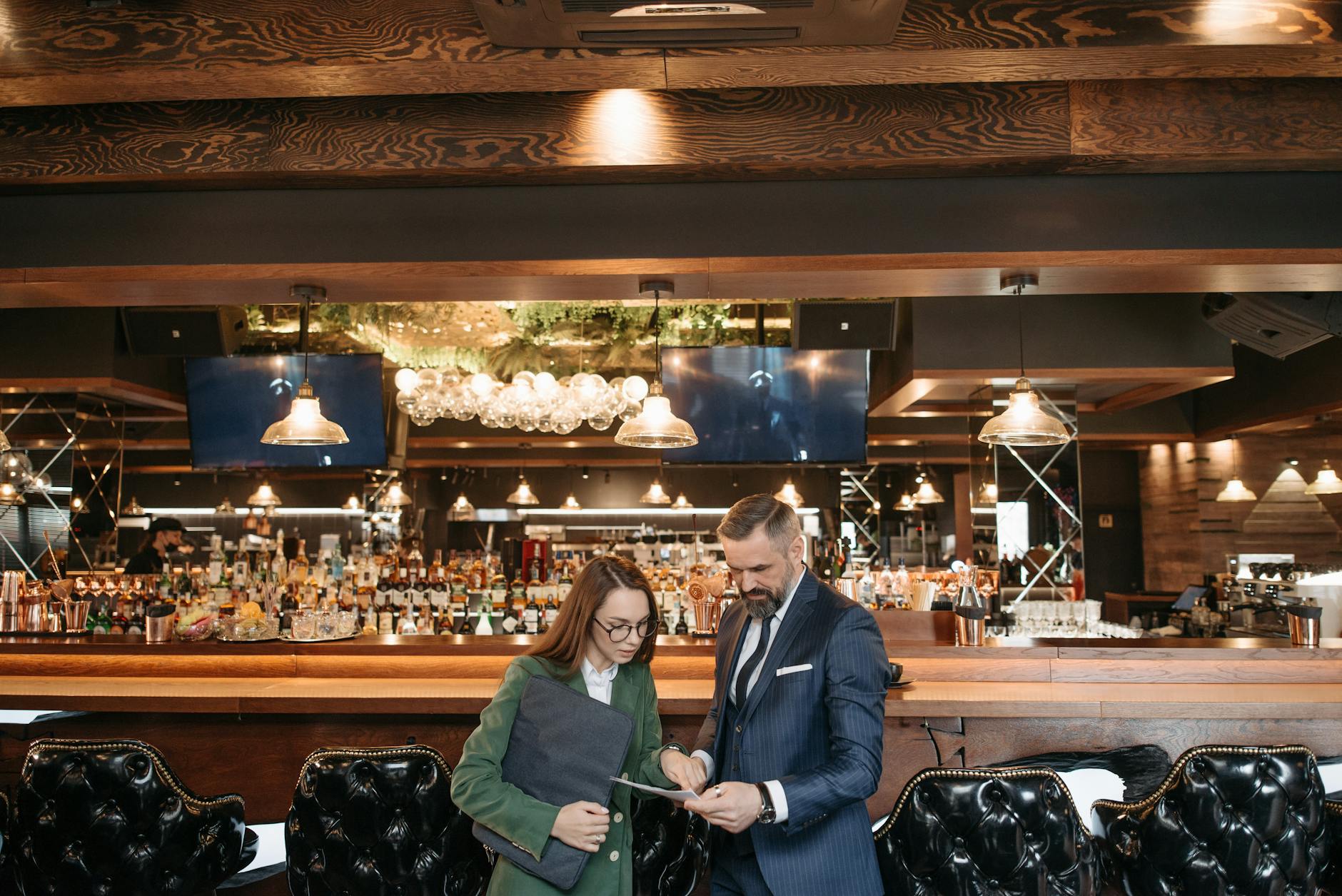 Business conversation over documents in a stylish bar interior