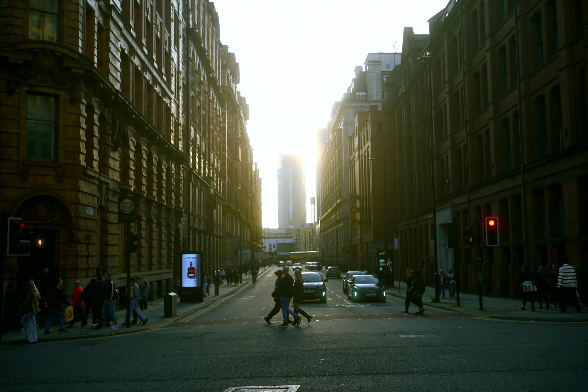 Manchester city street at sunset with pedestrians and cars