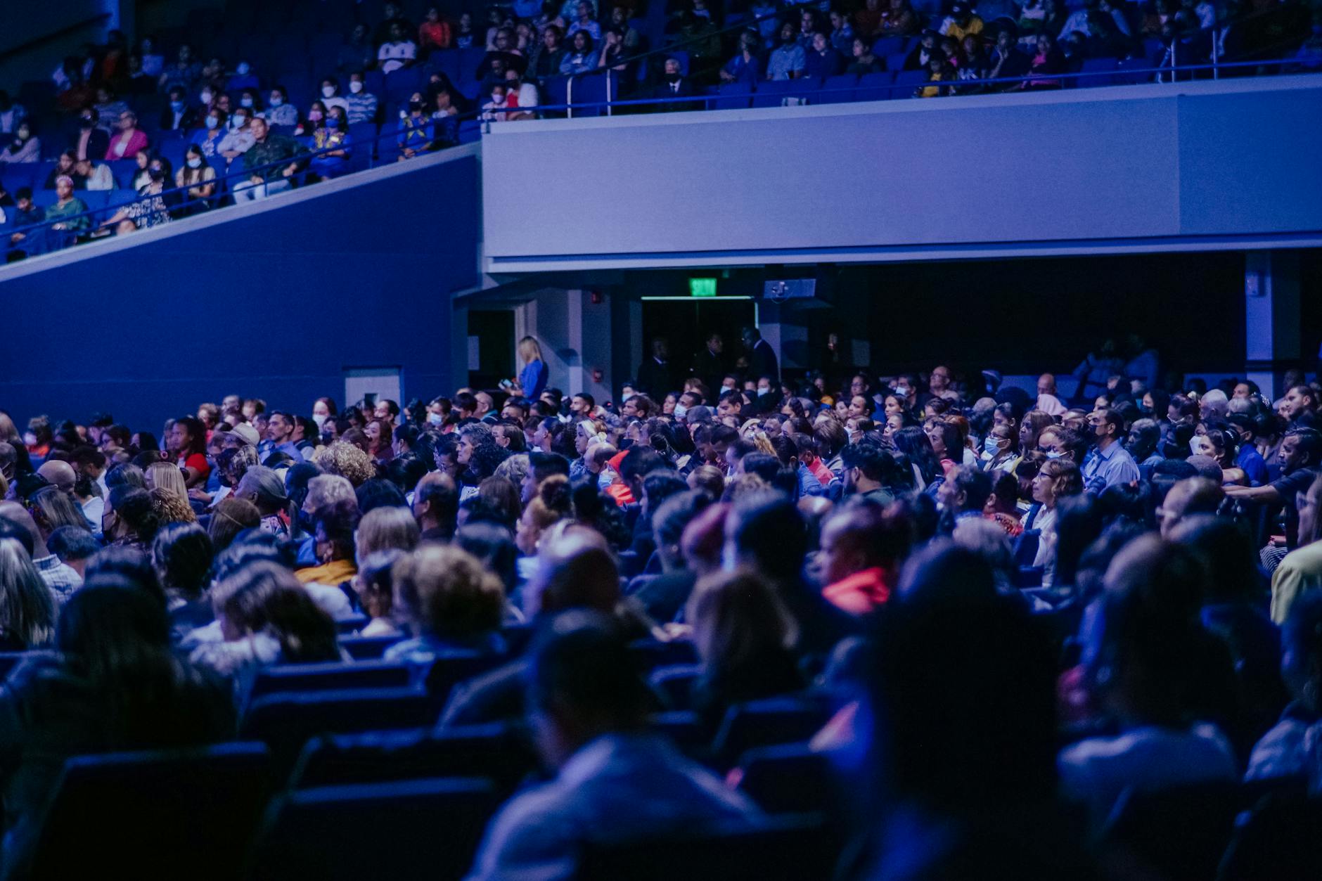 Crowded conference hall with audience members listening to a speaker