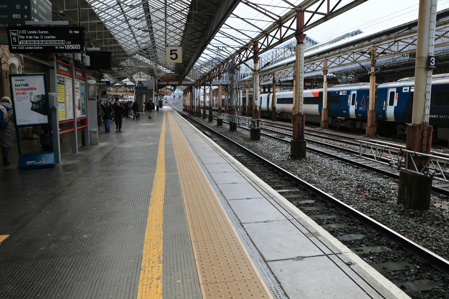 Passengers waiting on a train station platform in England