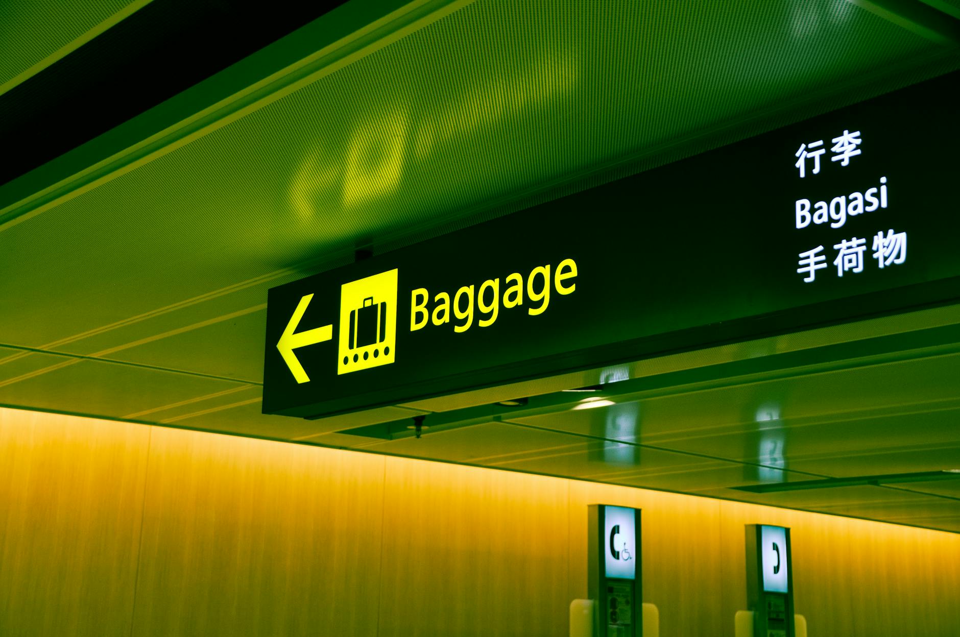 Airport baggage sign pointing travelers toward luggage collection