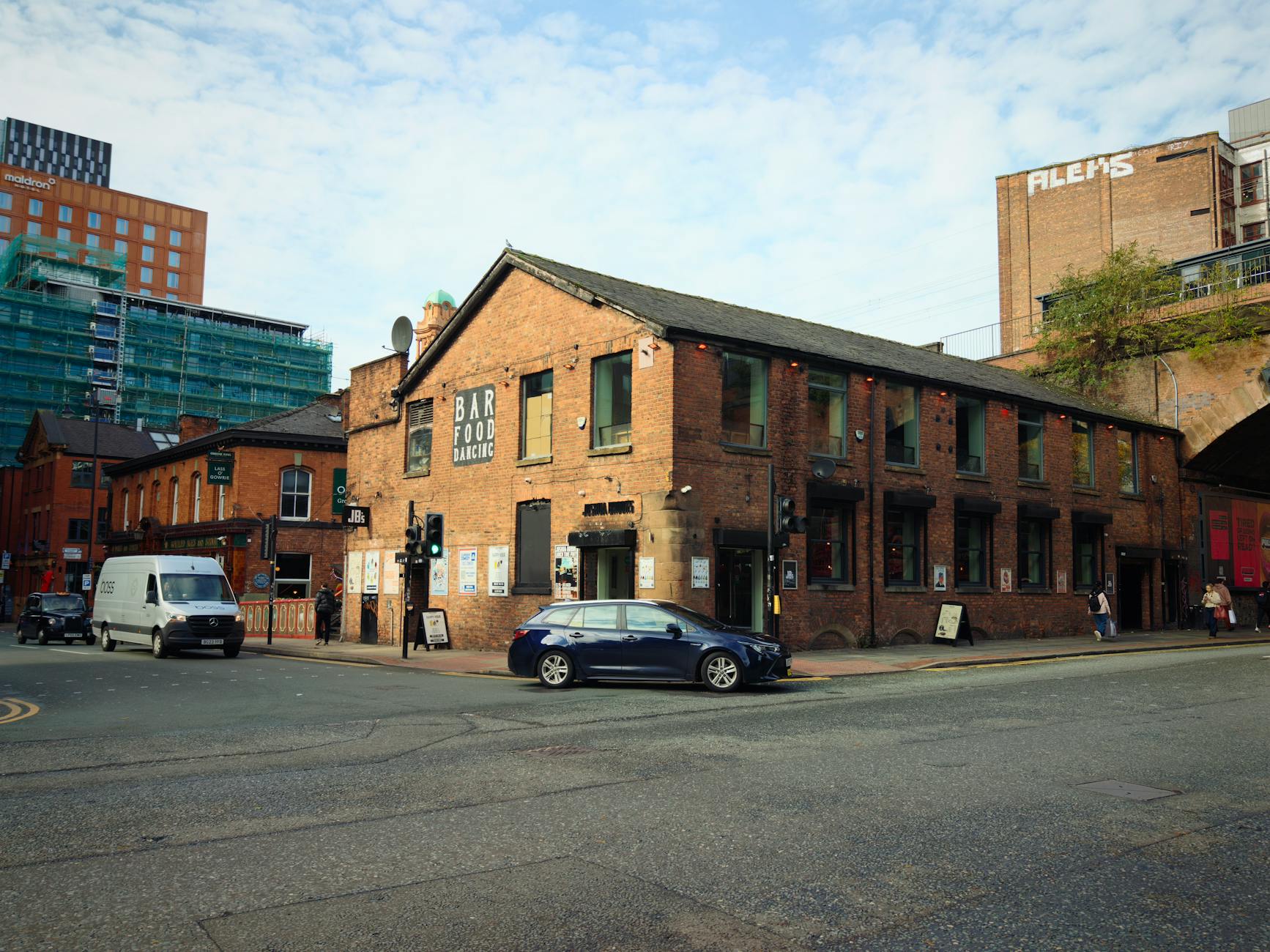 Manchester urban corner with historic brick buildings and street access