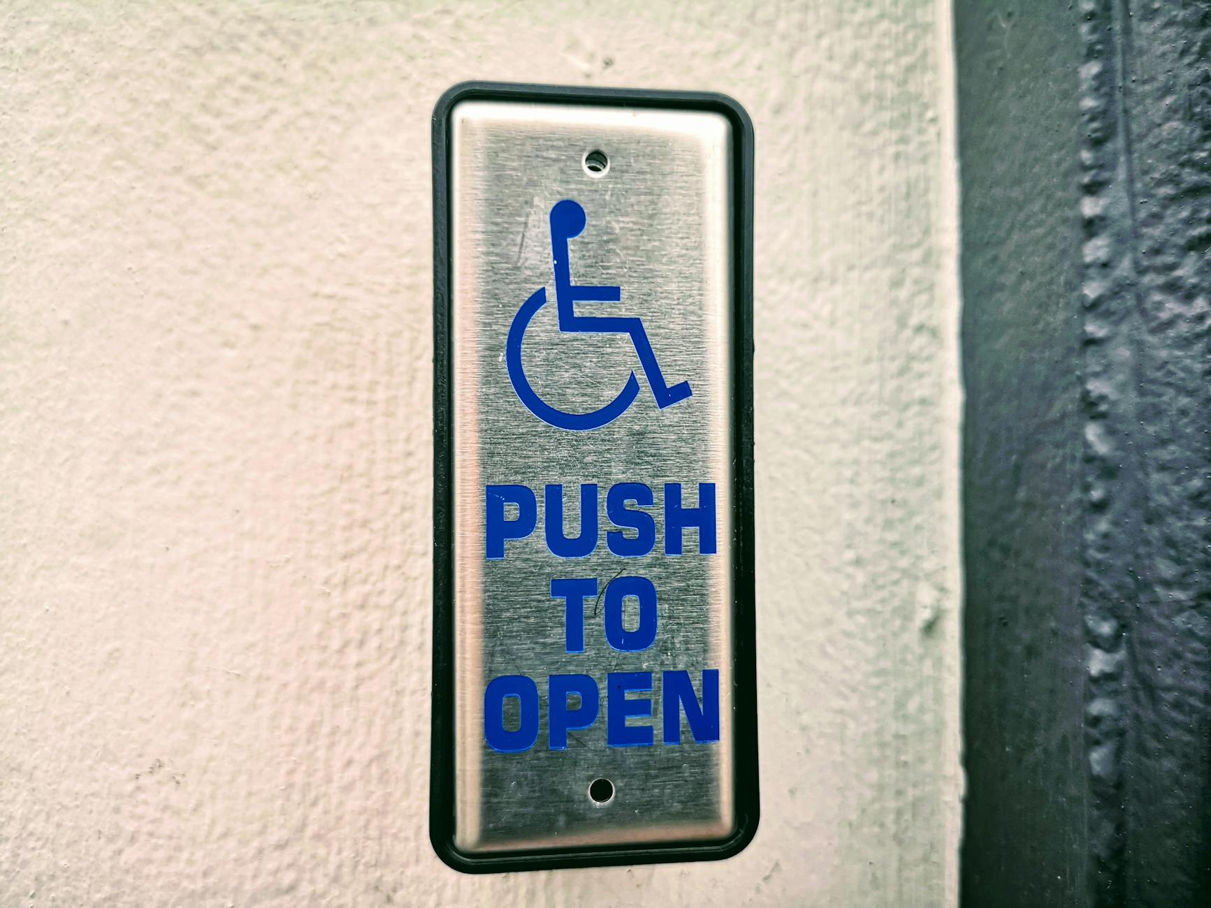 Close-up of an accessibility push button sign