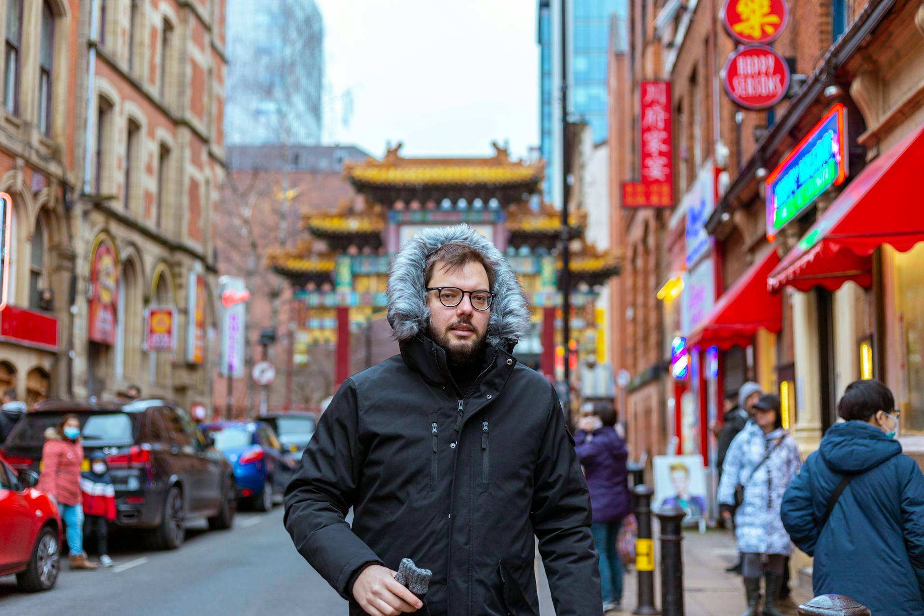 Pedestrian in Manchester Chinatown with colorful street backdrop