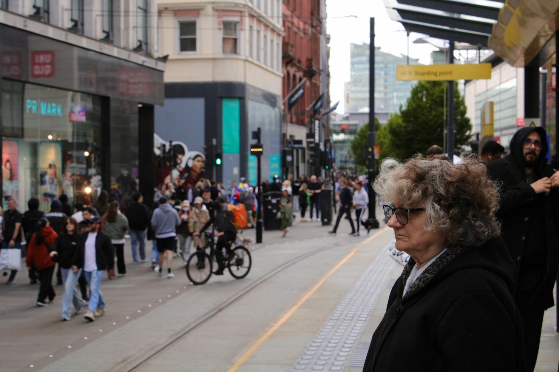 Lively city street with pedestrians, cyclists, and shops