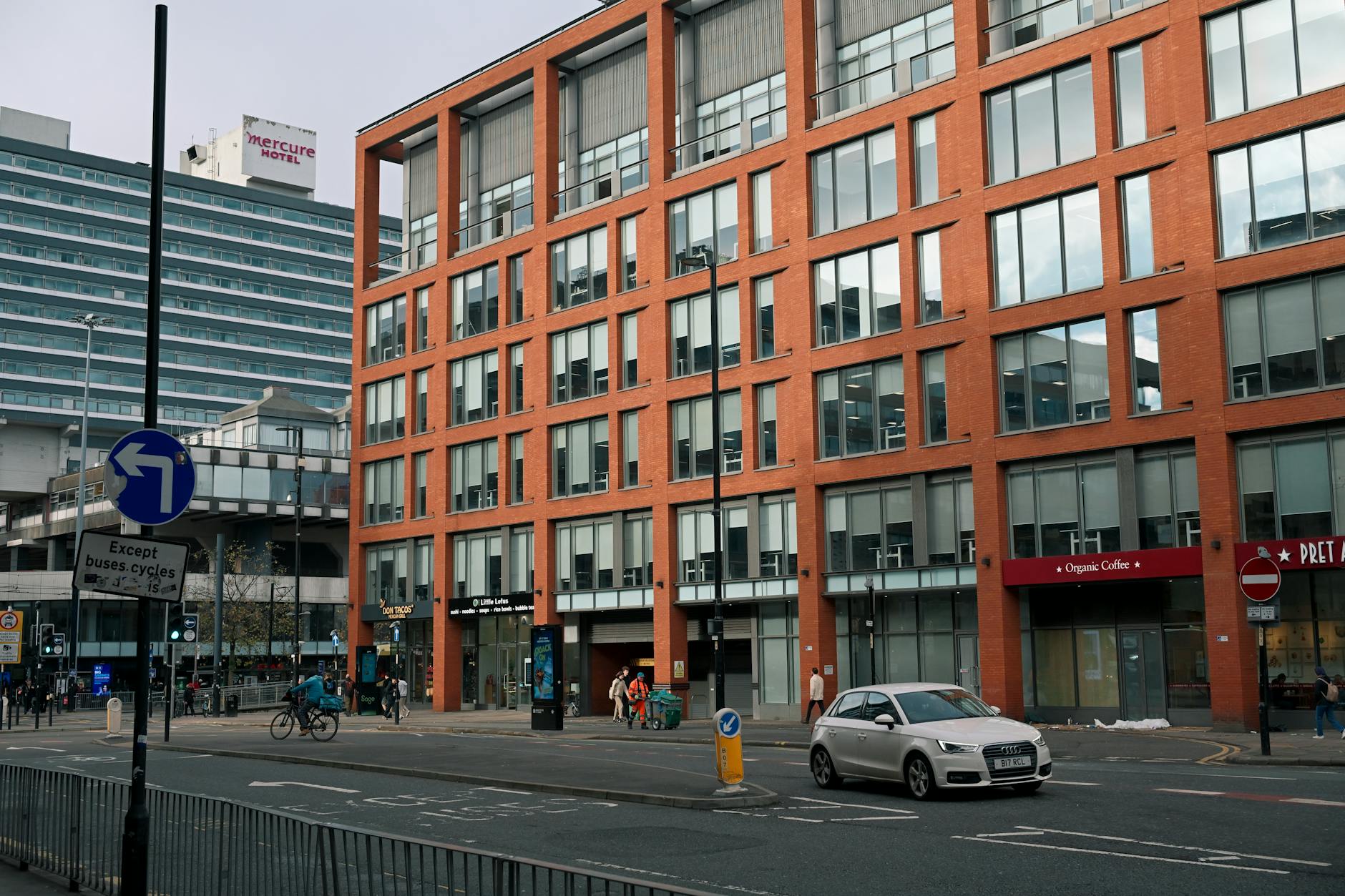 Manchester street with modern brick and glass buildings and traffic