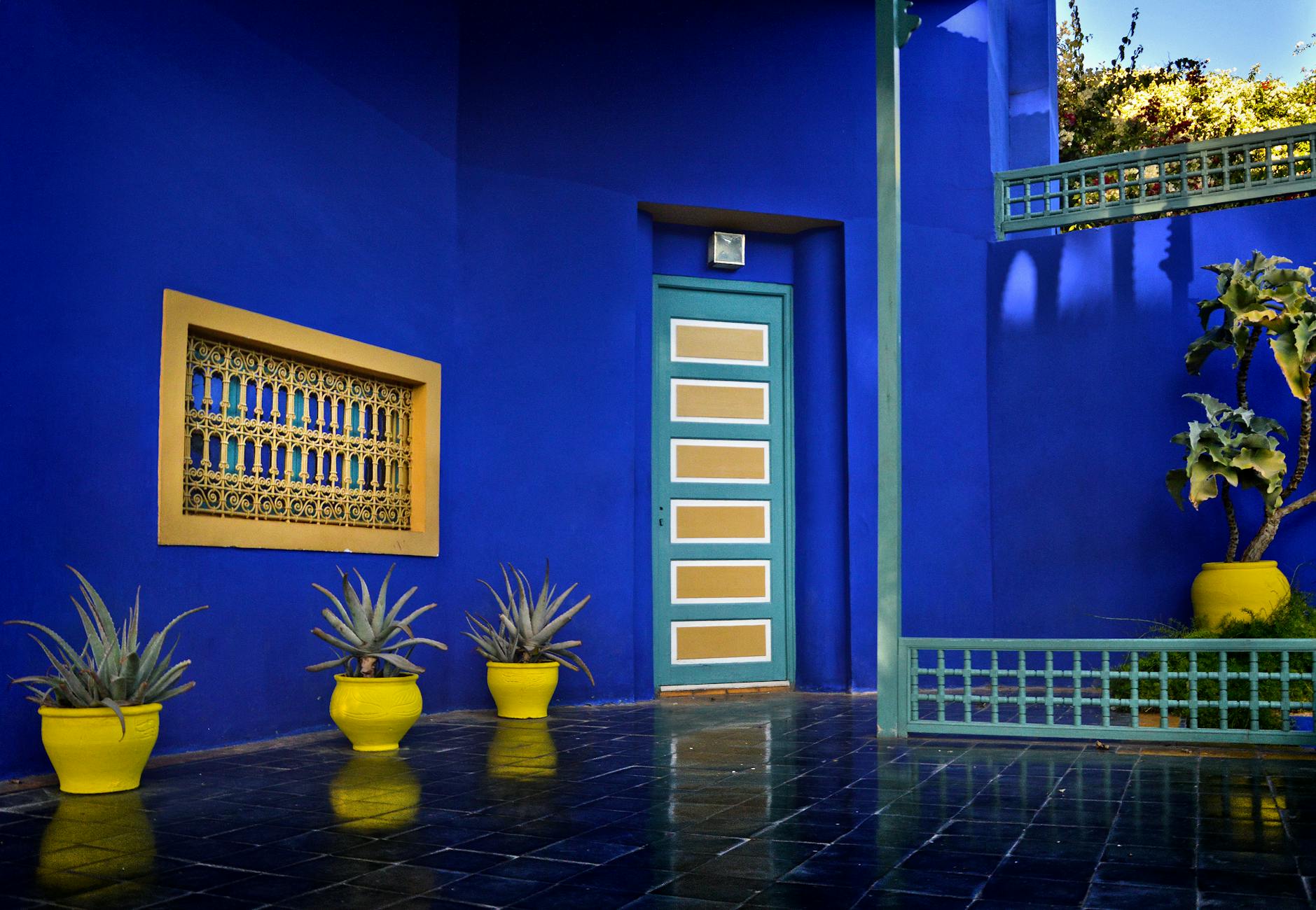 Bright Moroccan courtyard with blue walls and yellow planters