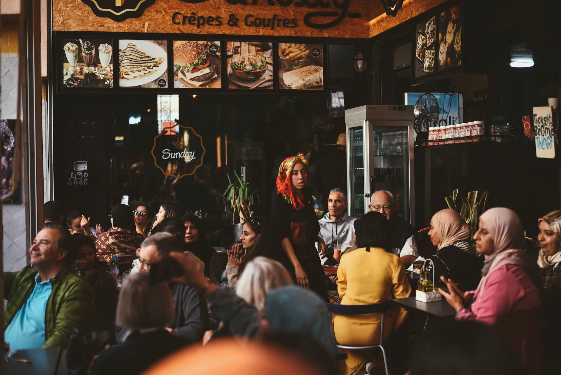 Busy Moroccan cafe with people gathered at tables