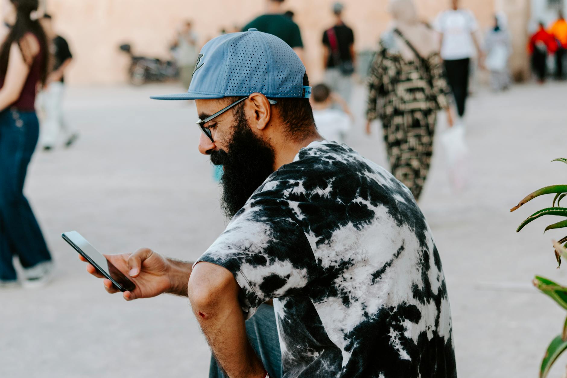 Man using a smartphone on a busy street in Rabat, Morocco