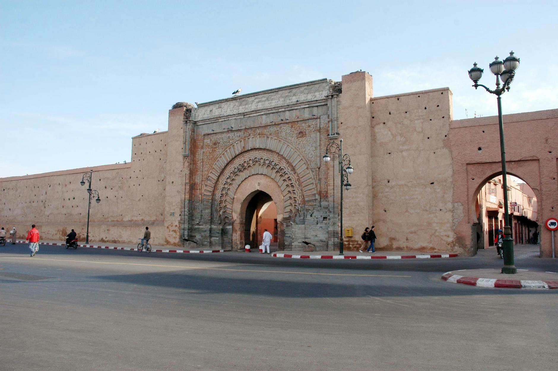 Historic city gate in Marrakech with people nearby