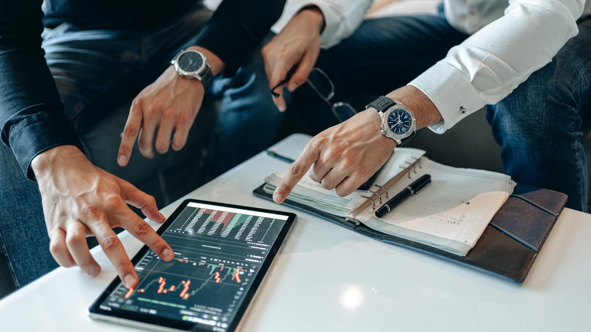 Businessmen reviewing financial data on a tablet