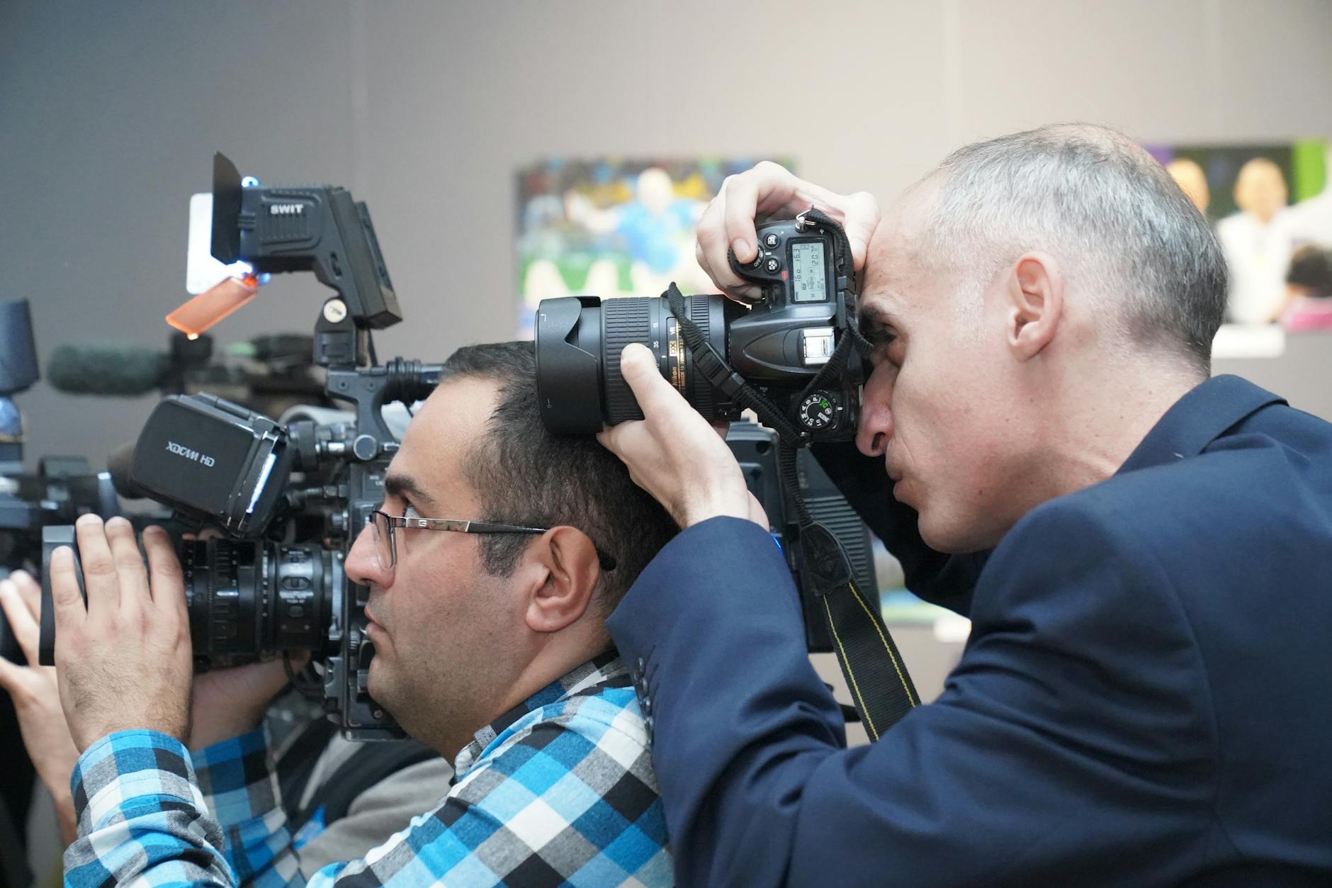 Professional photographers covering an event indoors