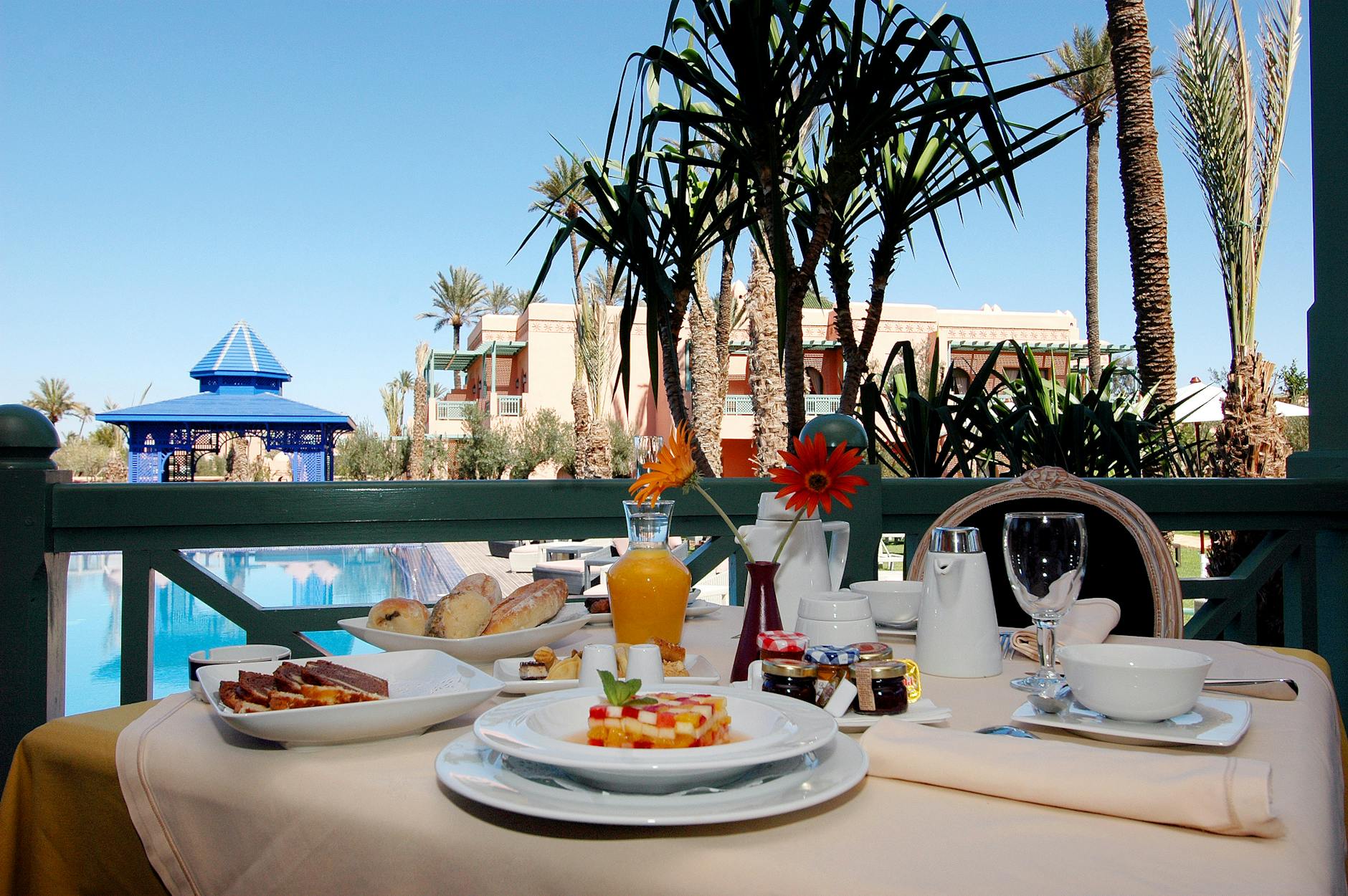 Elegant outdoor breakfast by a resort pool with palm trees
