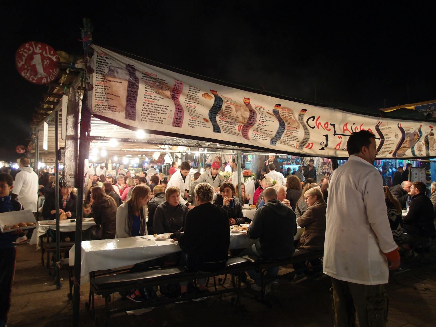 Crowded outdoor dining scene at a Moroccan market