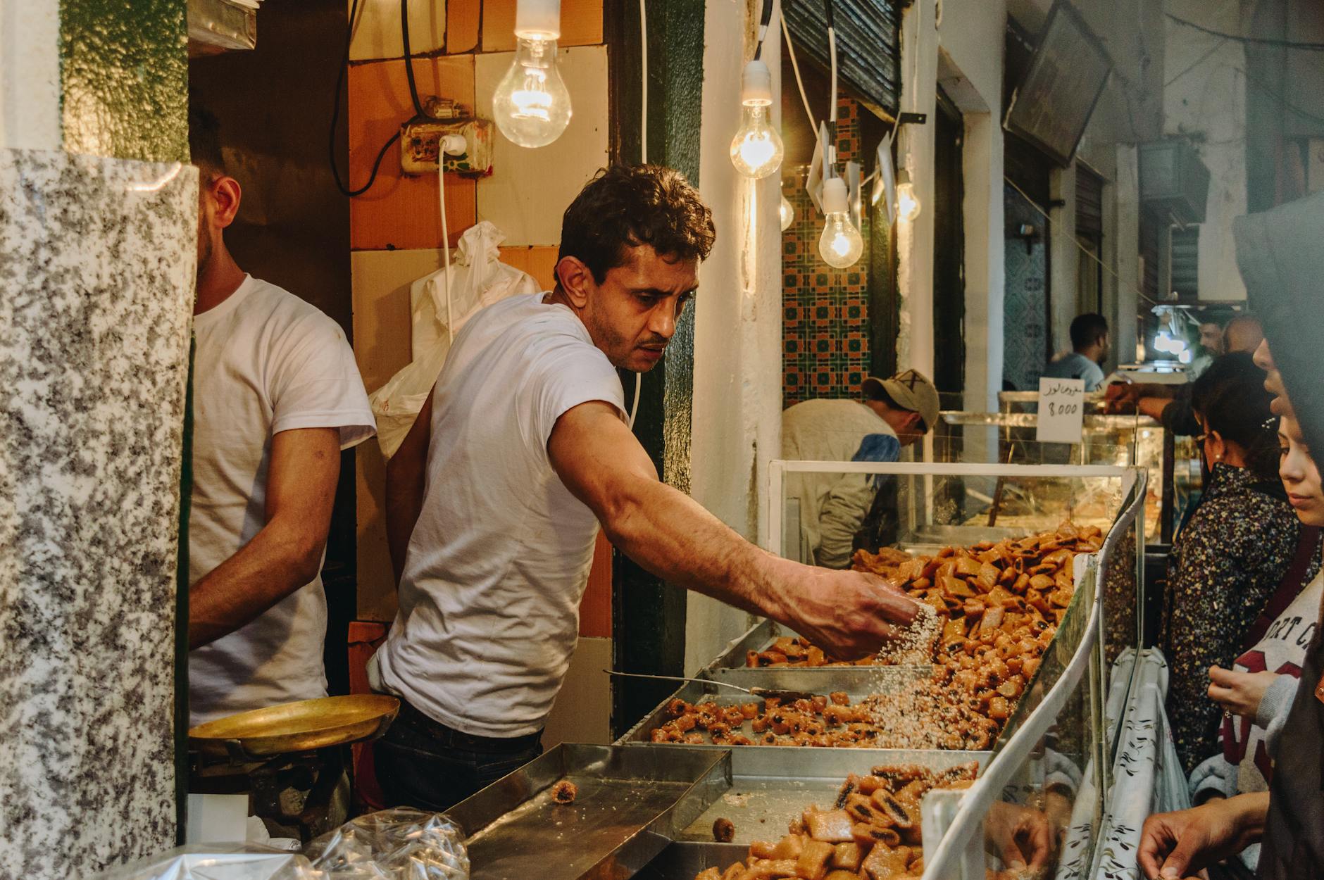 Vendor serving traditional sweets in a bustling market