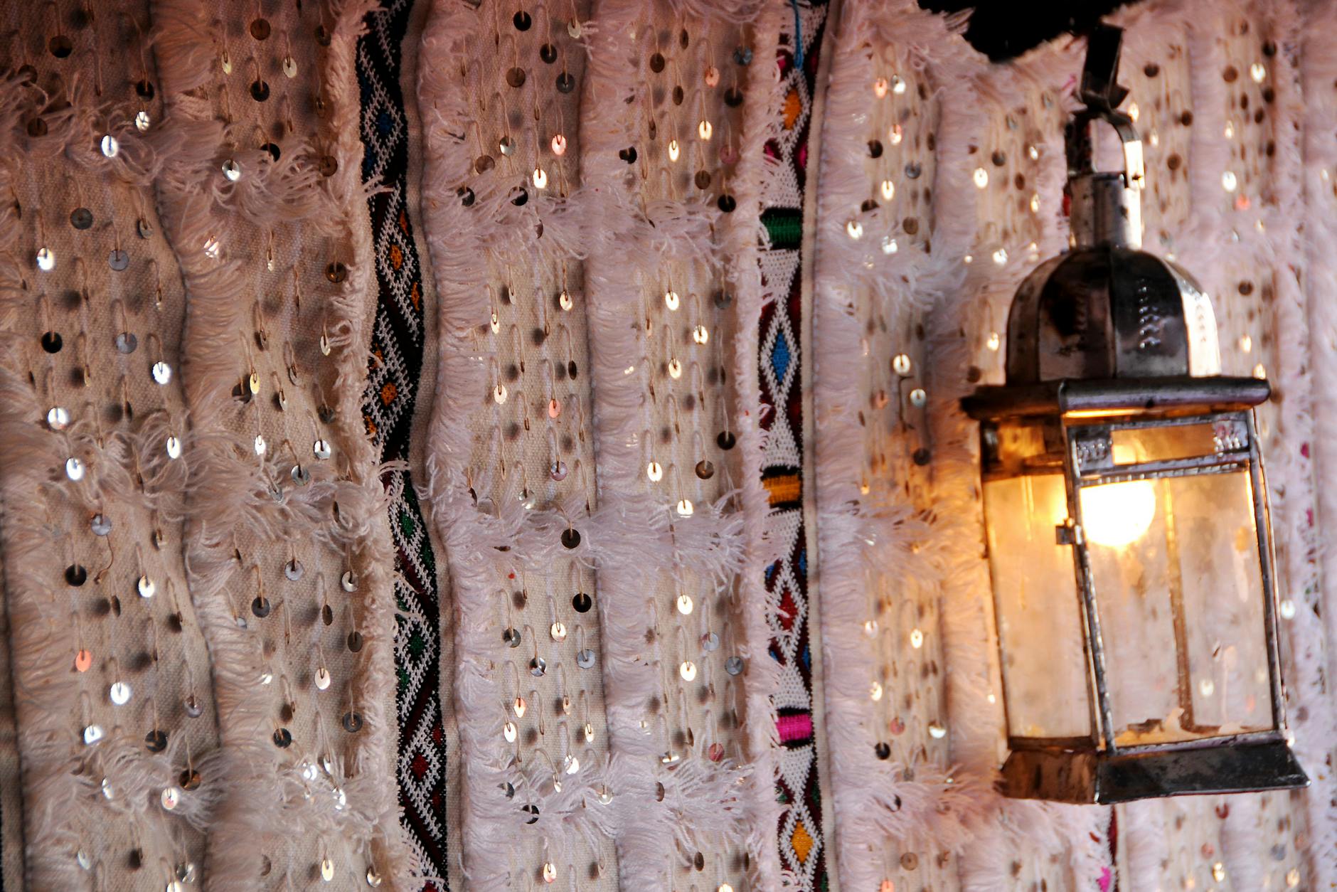 Traditional Moroccan lantern against patterned textiles